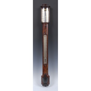 An English Regency flame mahogany and ebony strung stick barometer