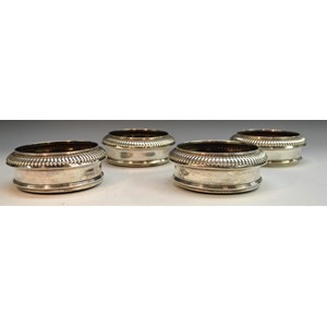 A set of four George III silver circular wine coasters