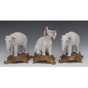 A garniture of three substantial 19th century ormolu mounted Continental porcelain models of elephants