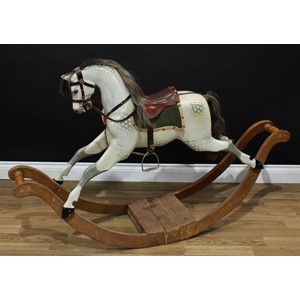 A good Edwardian dappled grey rocking horse on bow rockers, the carved, gesso and painted horse with pricked ears, flared nostrils, open mouth revealing carved teeth, the body with outstretched legs on a deeply curved elm rocker base with turned bails, real horse hair mane and tail, brown leather saddle and bridle, 146cm long, English c.1905