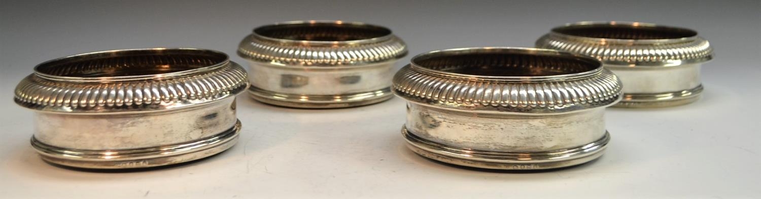 A set of four George III silver circular wine coasters