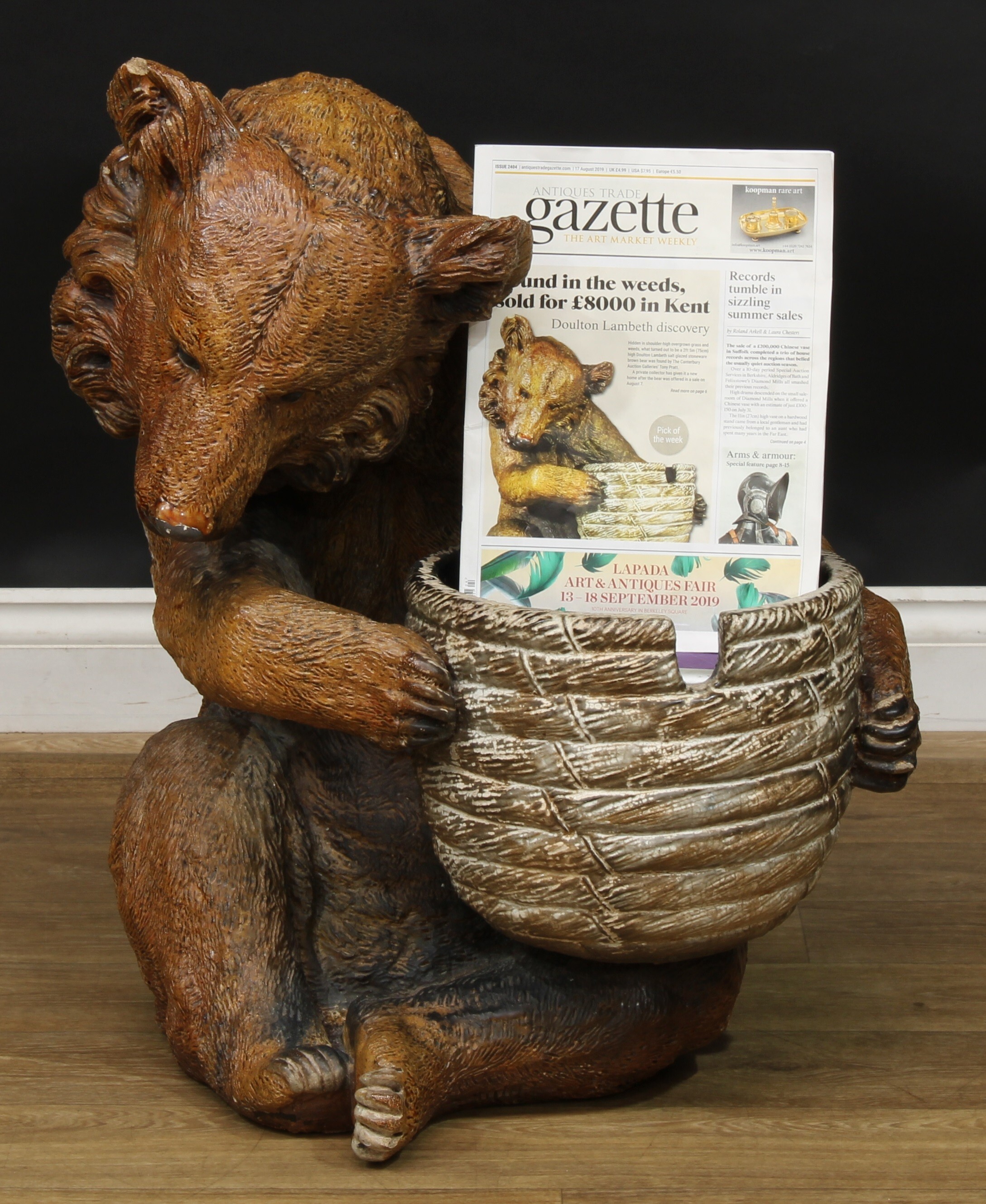 A substantial Doulton Lambeth salt glazed stoneware model, of a seated brown bear holding an upturned bee skep, possibly by Mark V. Marshall, impressed mark, 73cm high, 59cm wide, 65cm deep