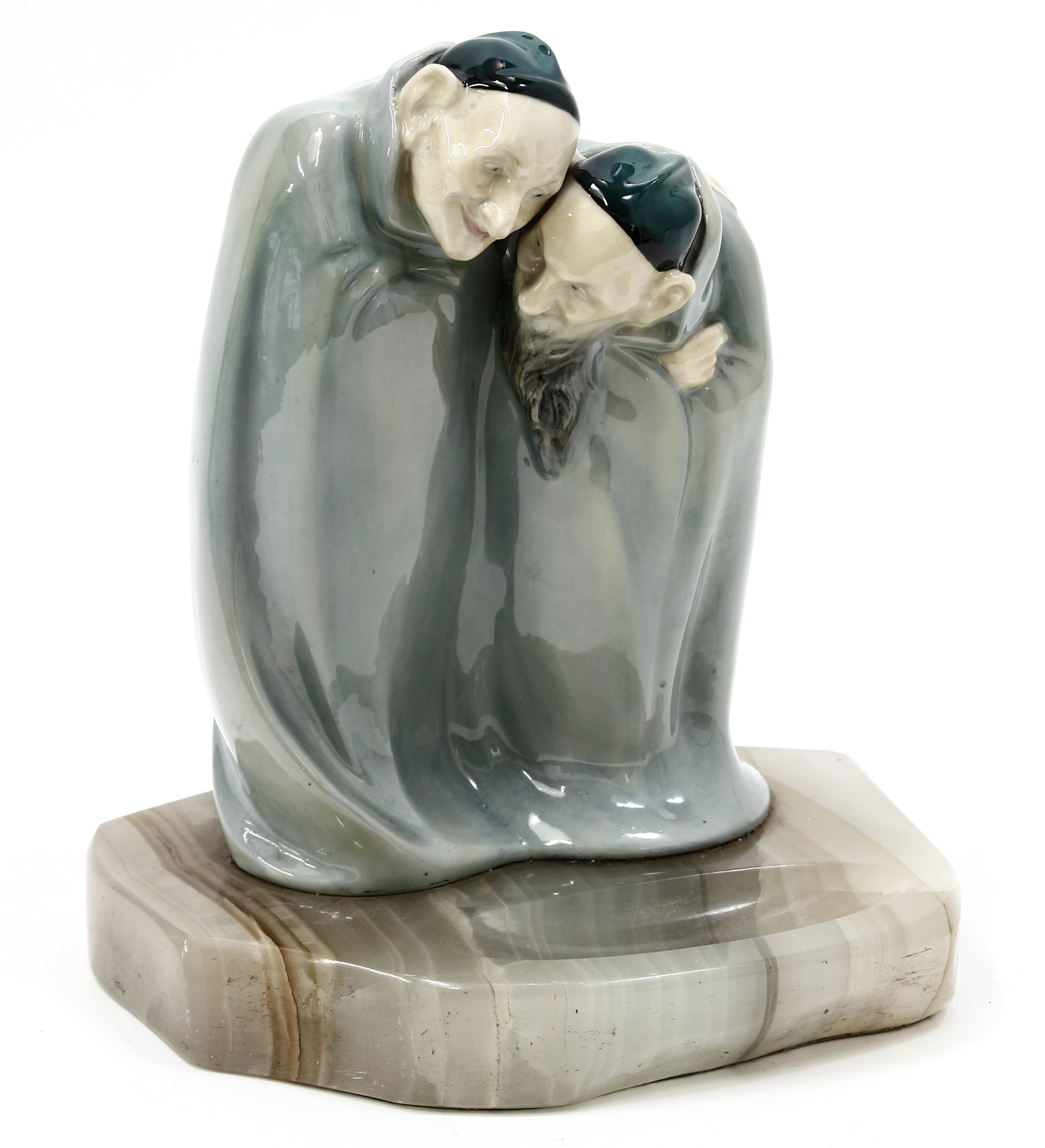 A Royal Doulton figure group, Spooks HN88, designed by Charles Noke, the pair of figures bent in conspiracy under Titanian gloss green cloaks, one bearded, each wearing a deep green skull cap, fixed to a green onyx base, 21.5cm, c.1920