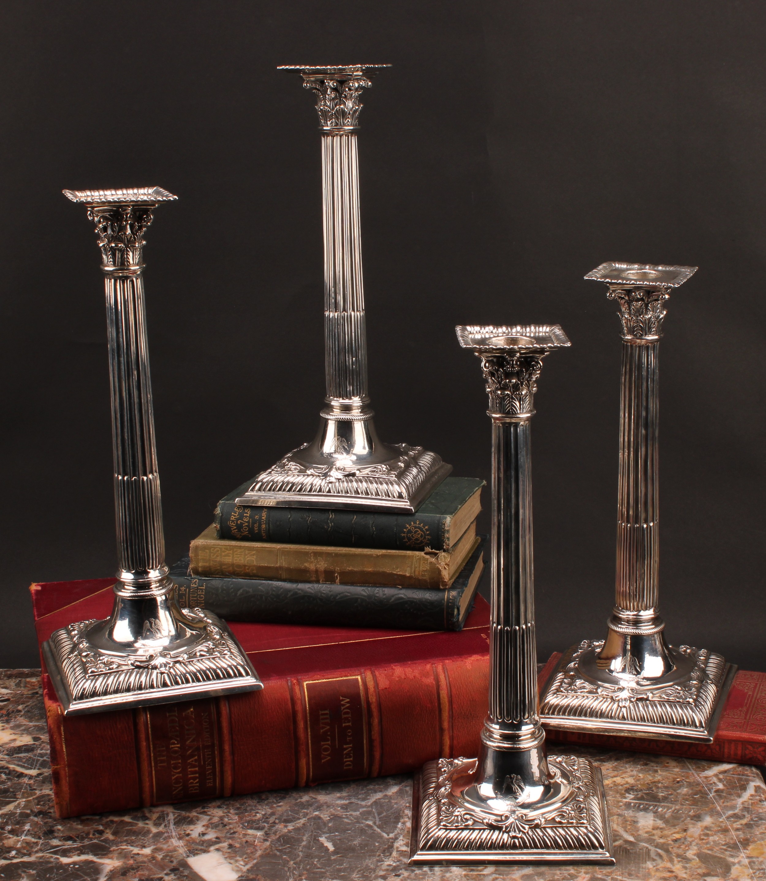 A set of four early George III cast silver Corinthian column table candlesticks