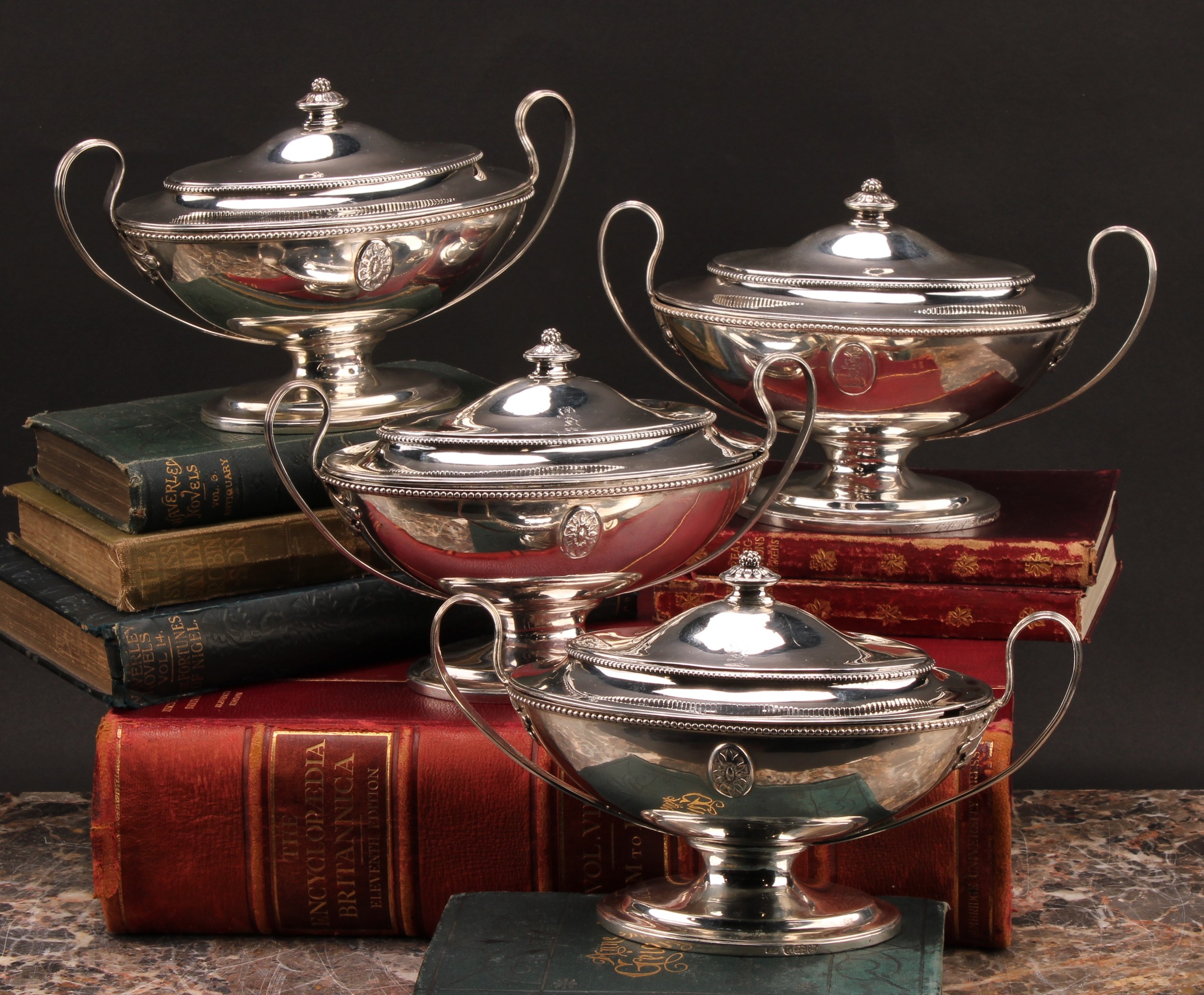A set of four George III Neo-Classical silver oval pedestal sauce tureens and covers