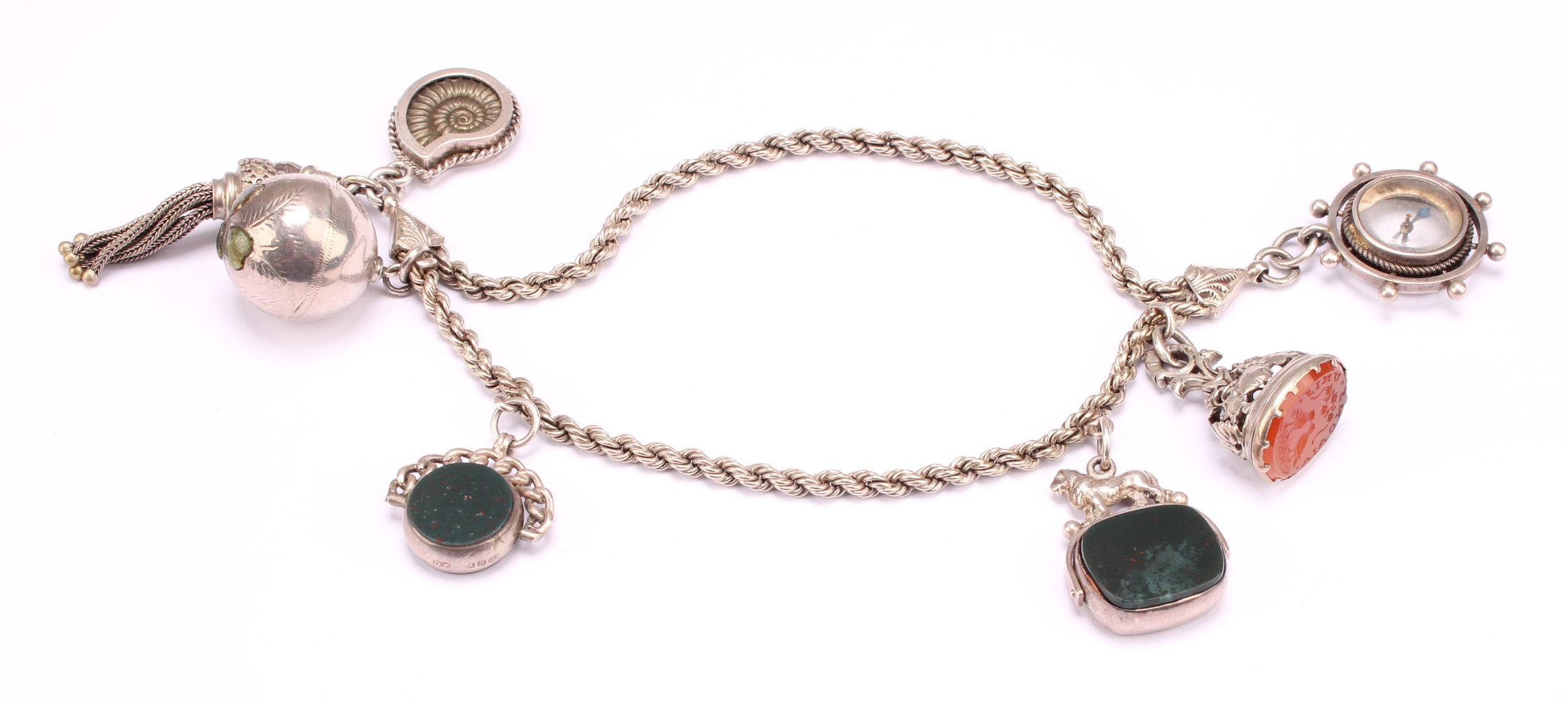 A Victorian silver bracelet suspending an oval carnelian seal stamp, with two doves beneath Vivons unis motto; two swivel fobs, compass, ammonite etc