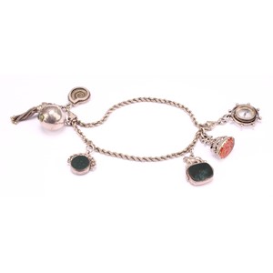 A Victorian silver bracelet suspending an oval carnelian seal stamp, with two doves beneath Vivons unis motto; two swivel fobs, compass, ammonite etc