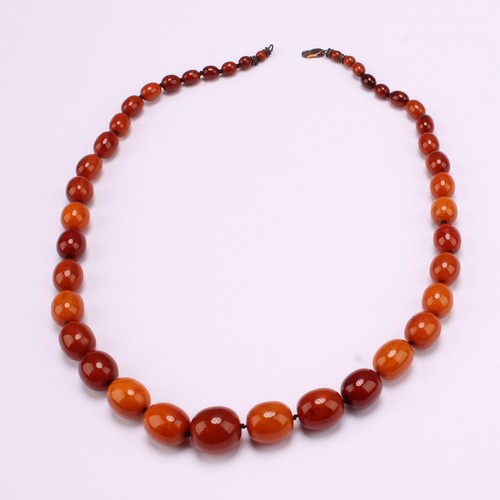 An Amber graduated bead knotted single strand necklace with "375" stamped 9ct gold clasp and unmarked white metal ends