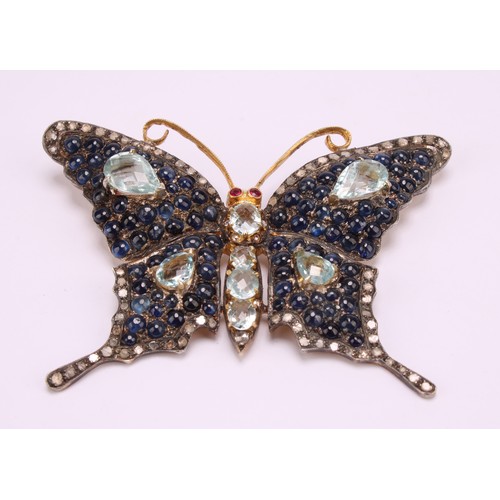 A large multi gem butterfly brooch, set with seventy two rose cut diamonds, eighty eight blue cabochon sapphires, eight pear and oval mixed cut aquamarines and two red spinels