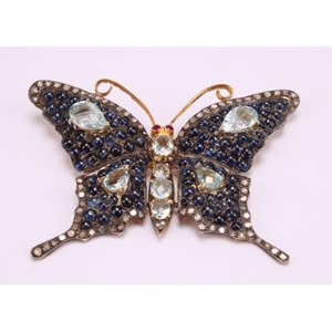 A large multi gem butterfly brooch, set with seventy two rose cut diamonds, eighty eight blue cabochon sapphires, eight pear and oval mixed cut aquamarines and two red spinels