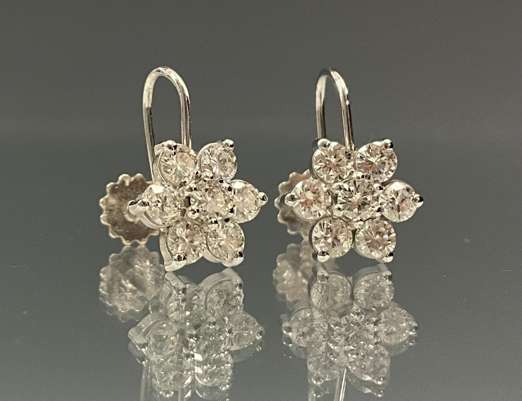 A pair of diamond cluster earrings, each set with seven round brilliant cut diamonds, total estimated diamond weight 1.40ct