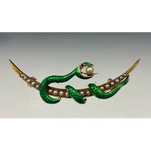 An early 20th century green enamel seed pearls serpent and crescent brooch
