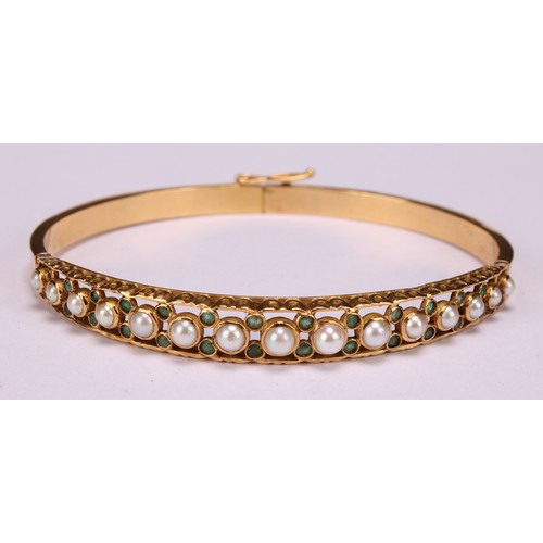 n 18ct gold hinged bangle, set with 15 graduated pearls