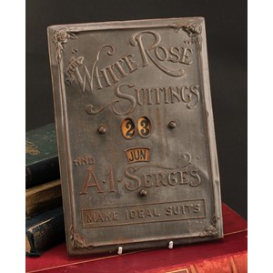 An early 20th century pressed tinplate perpetual calendar, The White Rose Suitings and A1 Serges