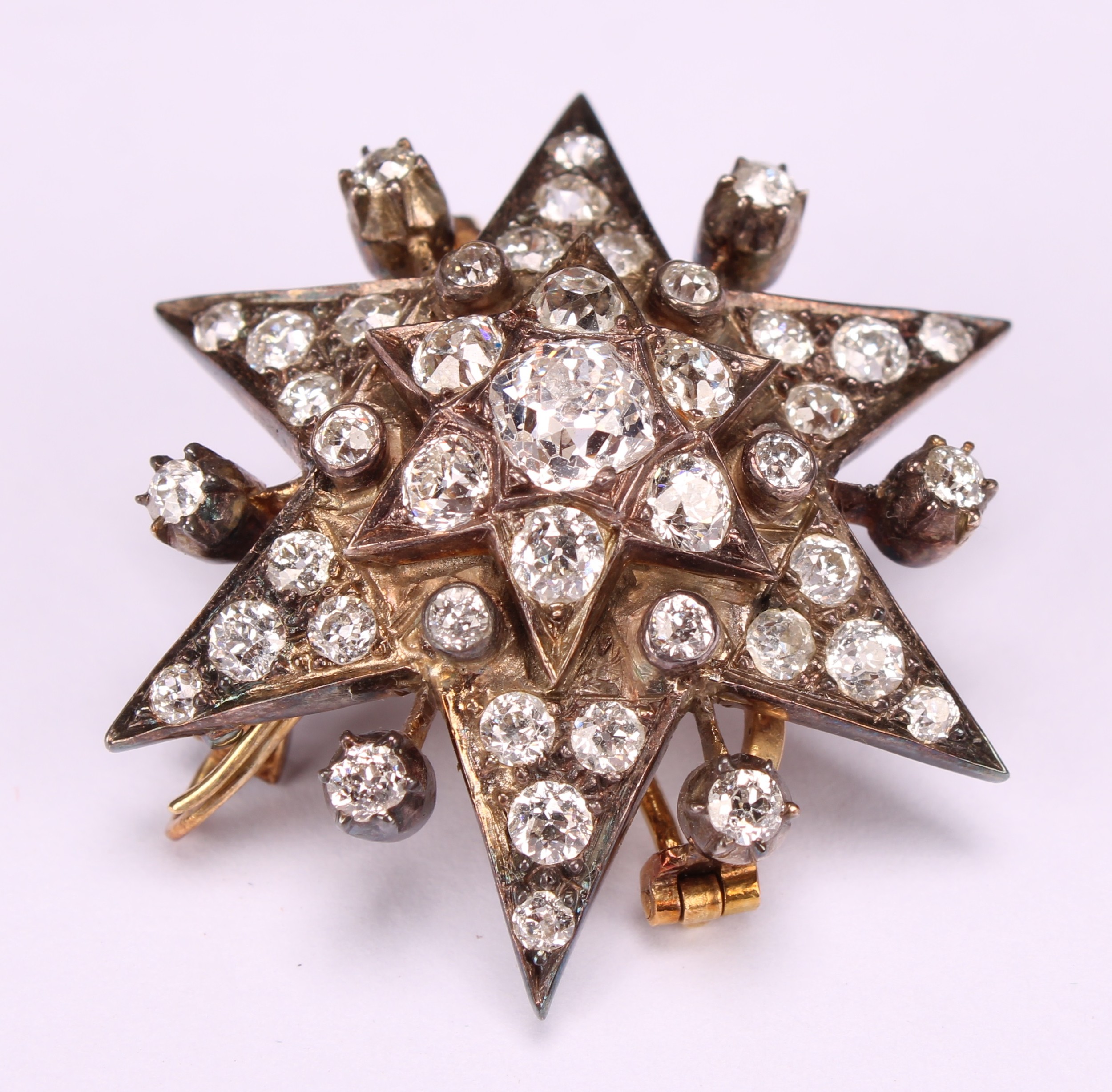 An early 20th century diamond set six pointed star pendant brooch