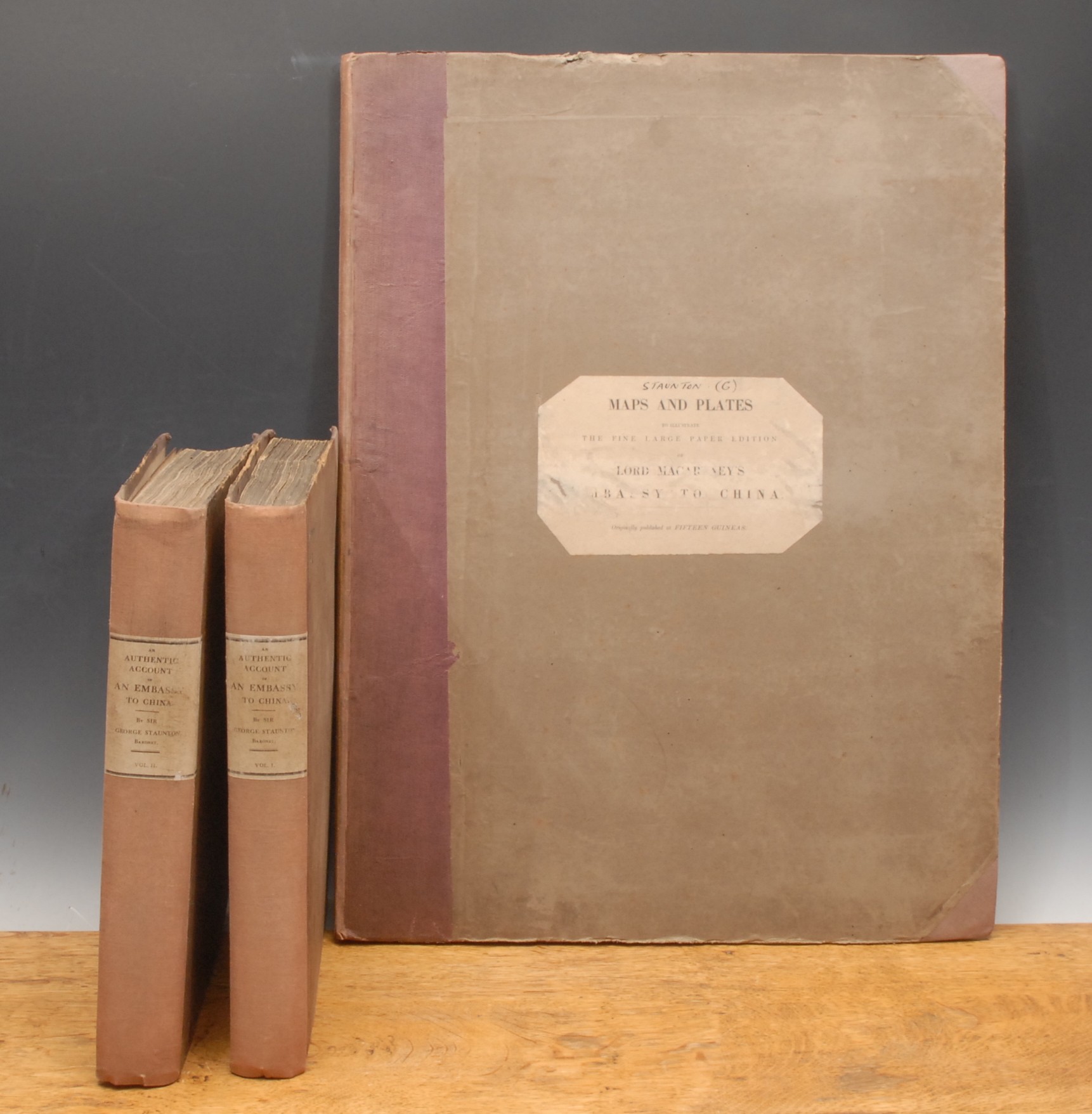 China, diplomatic – Staunton, (Sir George, Bt., FRS, LLD), An Authentic Account of an Embassy from the King of Great Britain to the Emperor of China; including cursory observations made, and information obtained, in travelling through that ancient empire, and a small part of Chinese Tartary. Together with a relation of the voyage undertaken on the occasion by His Majesty's Ship the Lion, and the ship Hindostan, in the East India Company's service, to the Yellow Sea, and Gulf of Pekin; as well as of their return to Europe; with notices of the several places where they stopped in the their way out and home; being the islands of Madeira, Teneriffe, and St. Jago; the port of Rio de Janeiro in South America; the islands of St. Helena, Tristan d'Acunha, and Amsterdam; the coast of Java, and Sumatra, the Nanka Isles, Pulo Condore, and Cochin-China. Taken chiefly from the papers of His Excellency the Earl of Macartney, Knight of the Bath, His Majesty's Embassador Extraordinary and Plenipotentiary to the Emperor of China; Sir Erasmus Gower, commander of the expedition, and of other gentlemen in the several departments of the embassy, 3 Vols. two of text with separate folio of plates, London, G. Nicol, 1797, large 4to bound faded maroon morocco over green boards, printed spine labels to Vols. I & II, marked MS on front boards Staunton I and Staunton II, Vol. I: xxxiv + 518pp, engraved frontis of Lord Macartney after Hickey, six engraved plates; Vol. II: xx + 626pp, engr. frontis. of Emperor Tchien Lung, 20 other engr. plates; Vol. III folio volume bound en suite, comprising 44 plates, including maps, some folding, printed title applied to front board, spines faded and some foxing to titles and end pages, ex. lib. Irish Royal College of Surgeons (3)