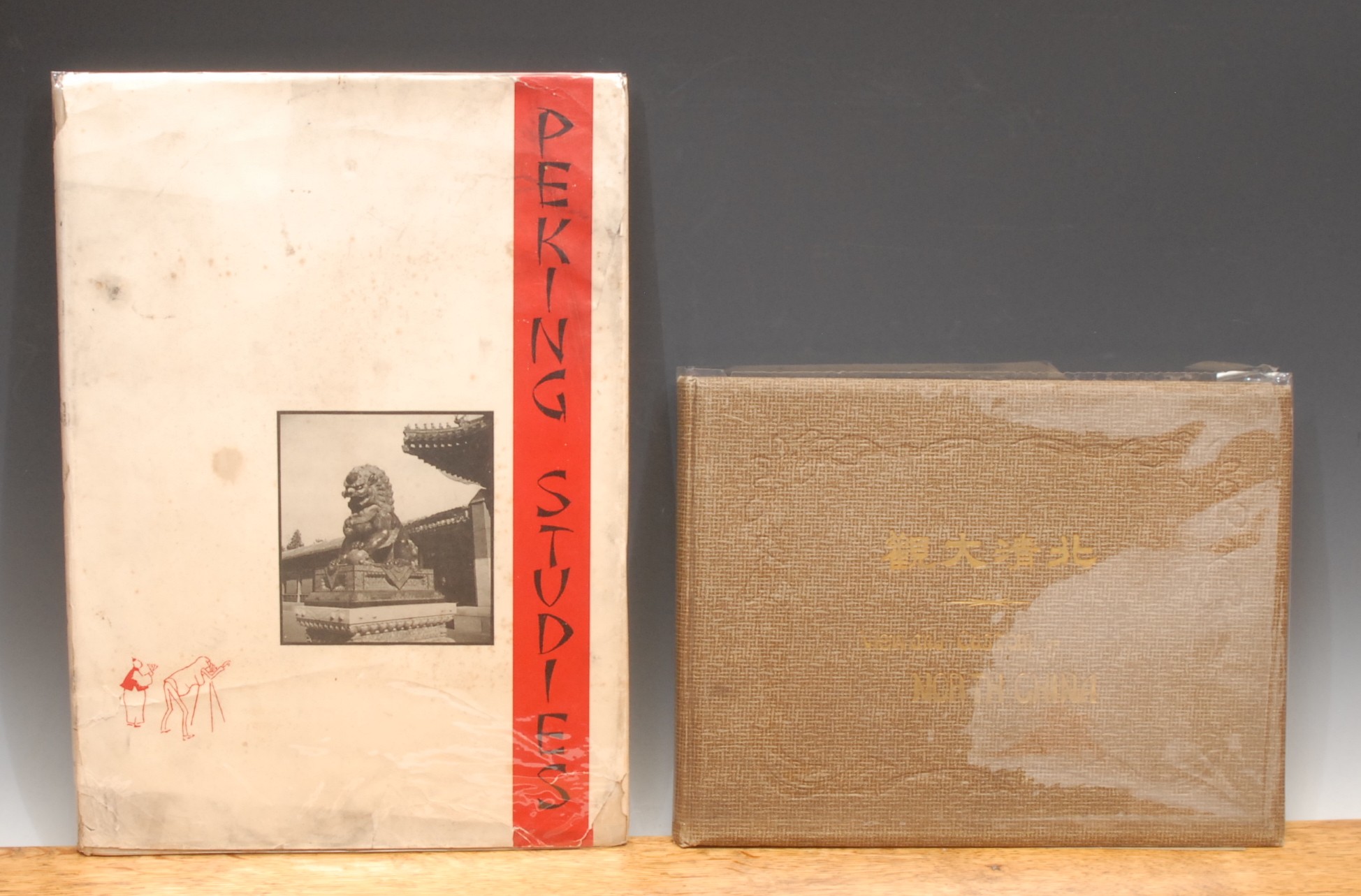 China, topography – Catleen (Ellen), Peking Studies, shanghai, Kelly & Walsh, 1934, large 4to, 87pp, traditional style tincture map of Peking (Beijing) numerous monochromatic photographs – portraits, social scenes, architecture and topography – some colourised, monochrome and colour printed vignettes to text, dedication on flyleaf dated 1935, buff boards, black printed title on red vertical strip mounted photograph and red printed vignette to front board, black spine titles, d. w. with tear at lower edge, in plastic protector; A Chinese-produced album with English sub-title translations, View and Custom [sic] of North China, Tien Tsin, S. Kojima 1909, landscape 4to, 92 mainly coloured plates of scenes, monuments and architecture, captioned in Chinese with English beneath, some with multiple images, grey endpapers, embossed faux basket weave brown boards gilt titles, with later plastic wrapper (2)