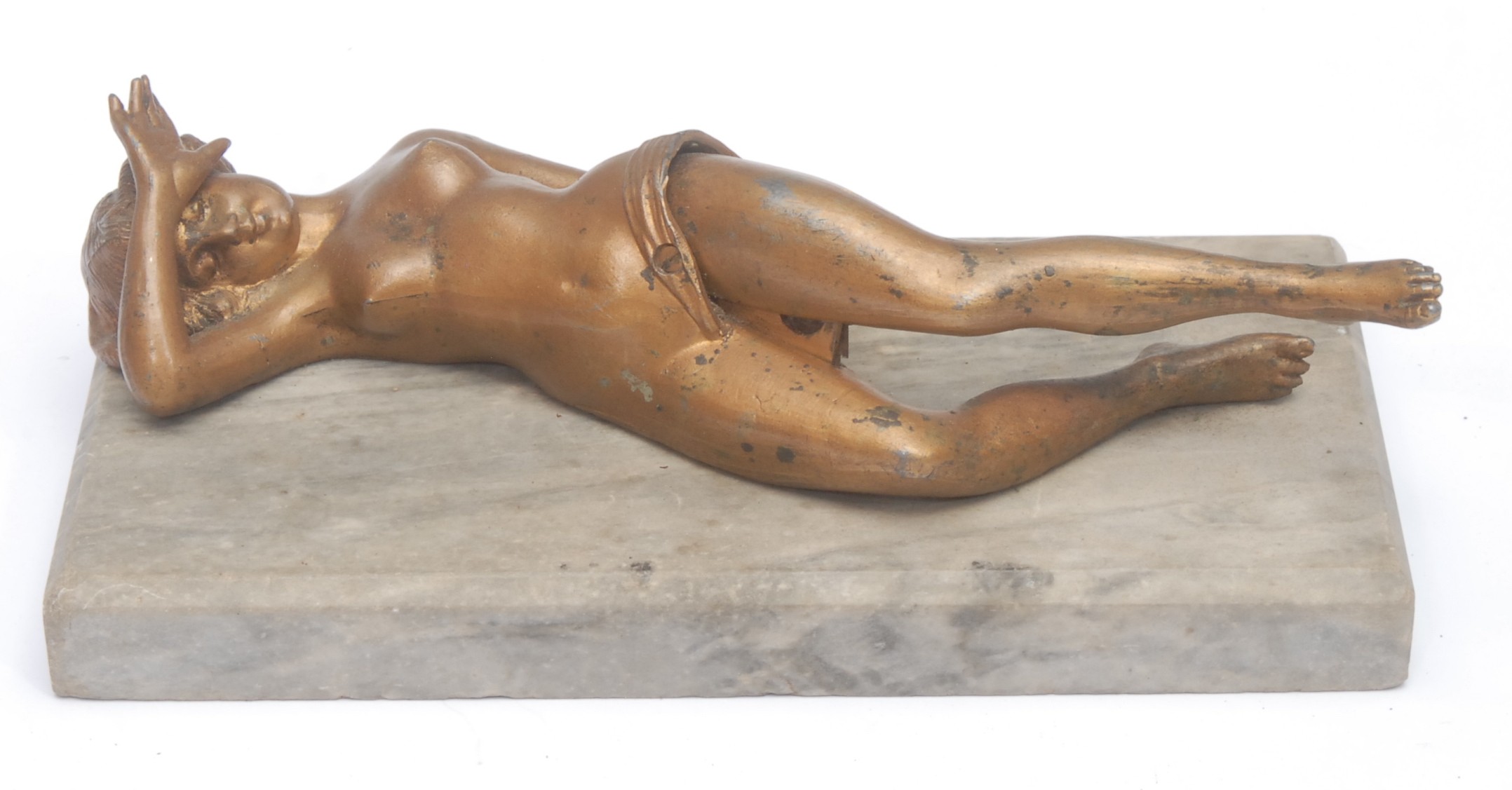 An Art Deco gilt metal erotic cigar cutter, as a reclining nude, her legs separating on a pivot to reveal a blade, marble base, 19.5cm long