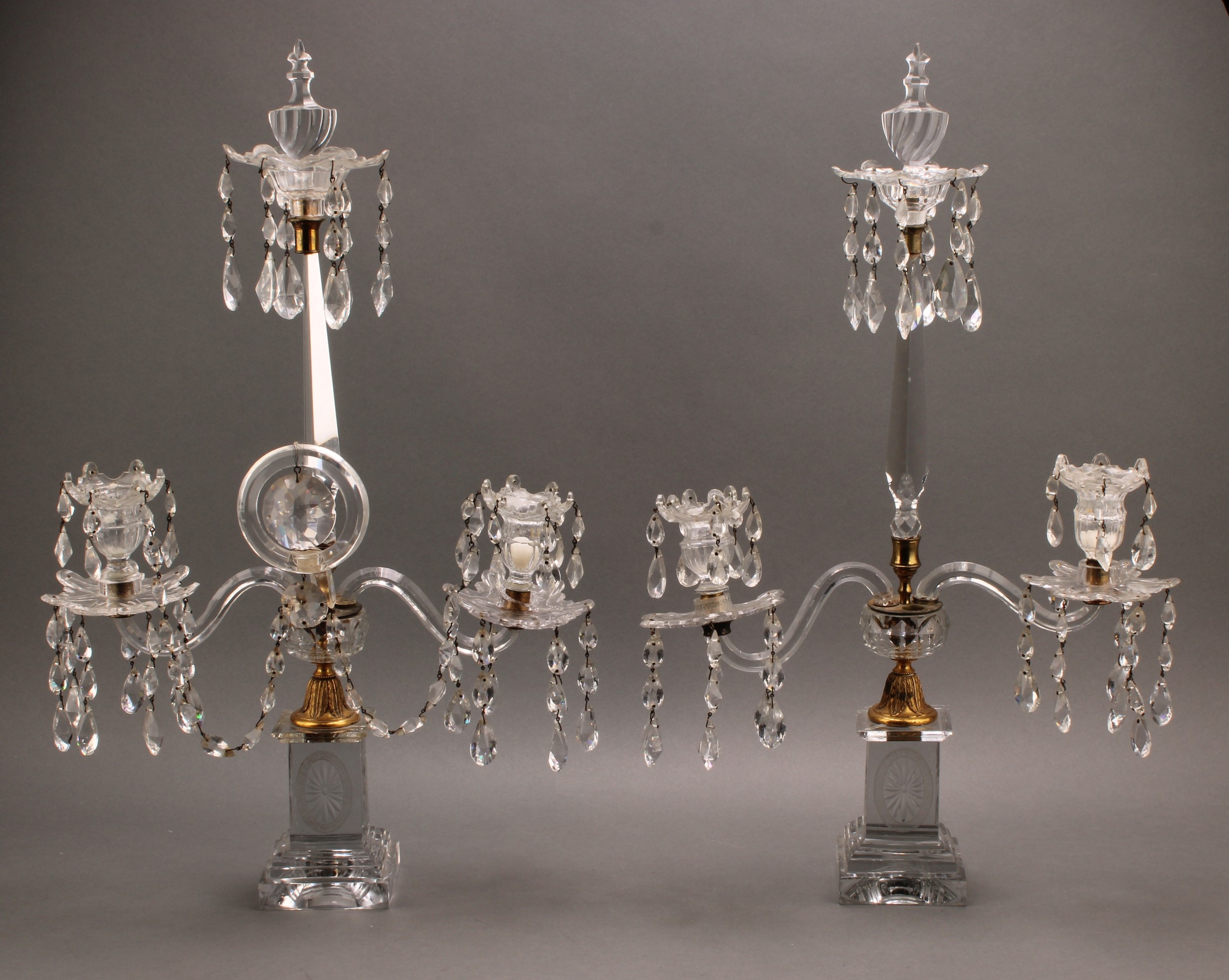A pair of Venetian gilt metal and glass two-branch lustre candelabra, shaped drip pans suspended with facetted droppers, square plinth base, 60cm high, 19th century