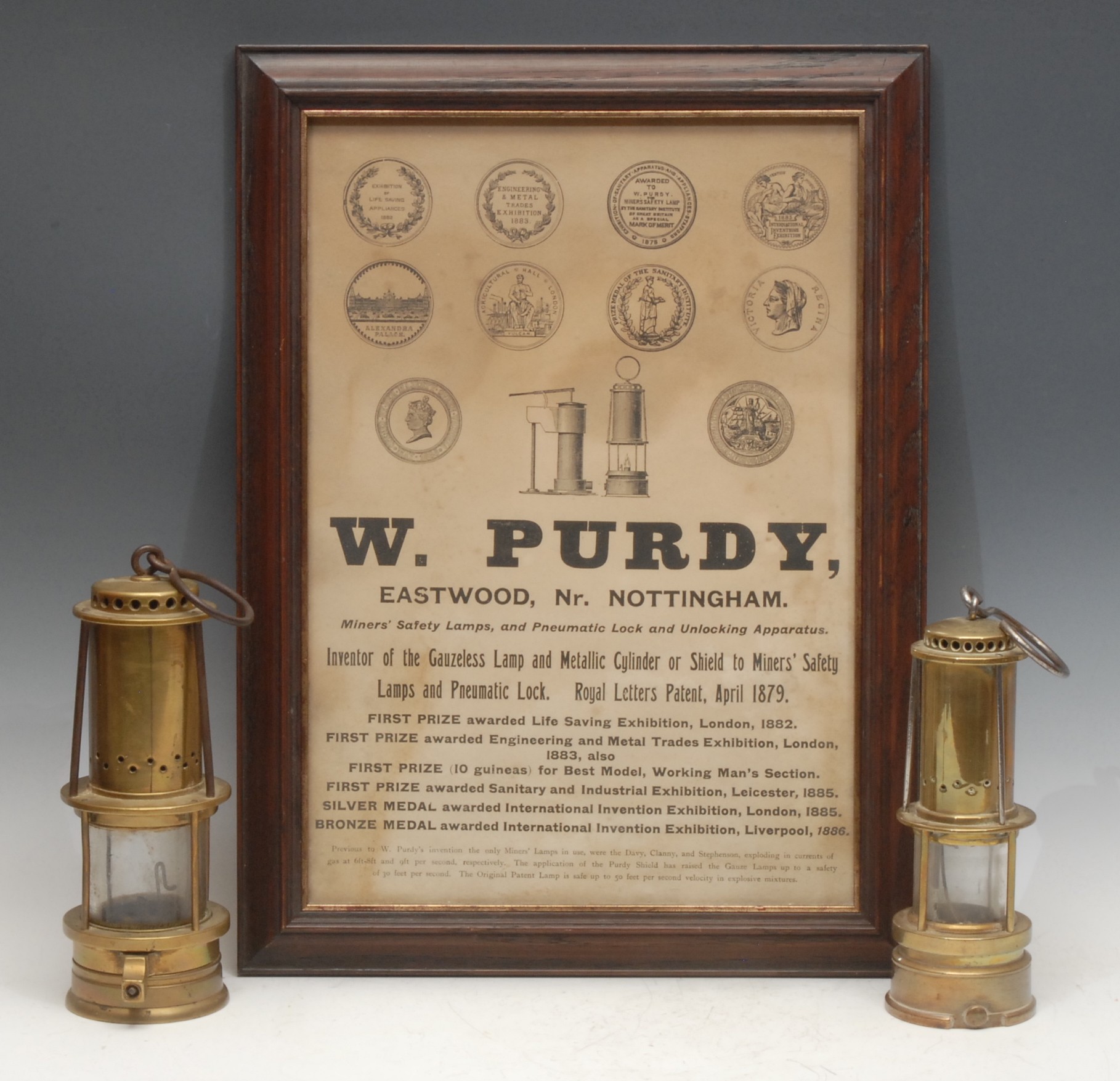 Coal Mining Interest - two 19th century brass miner's lamps, by William Purdy, bearing the inscription Purdy's Patent, perforated chimeys above gauze lined glass chambers, the largest 24cm high overall; a 19th century W. Purdy, Nottingham printed advertisement ensuite (3)