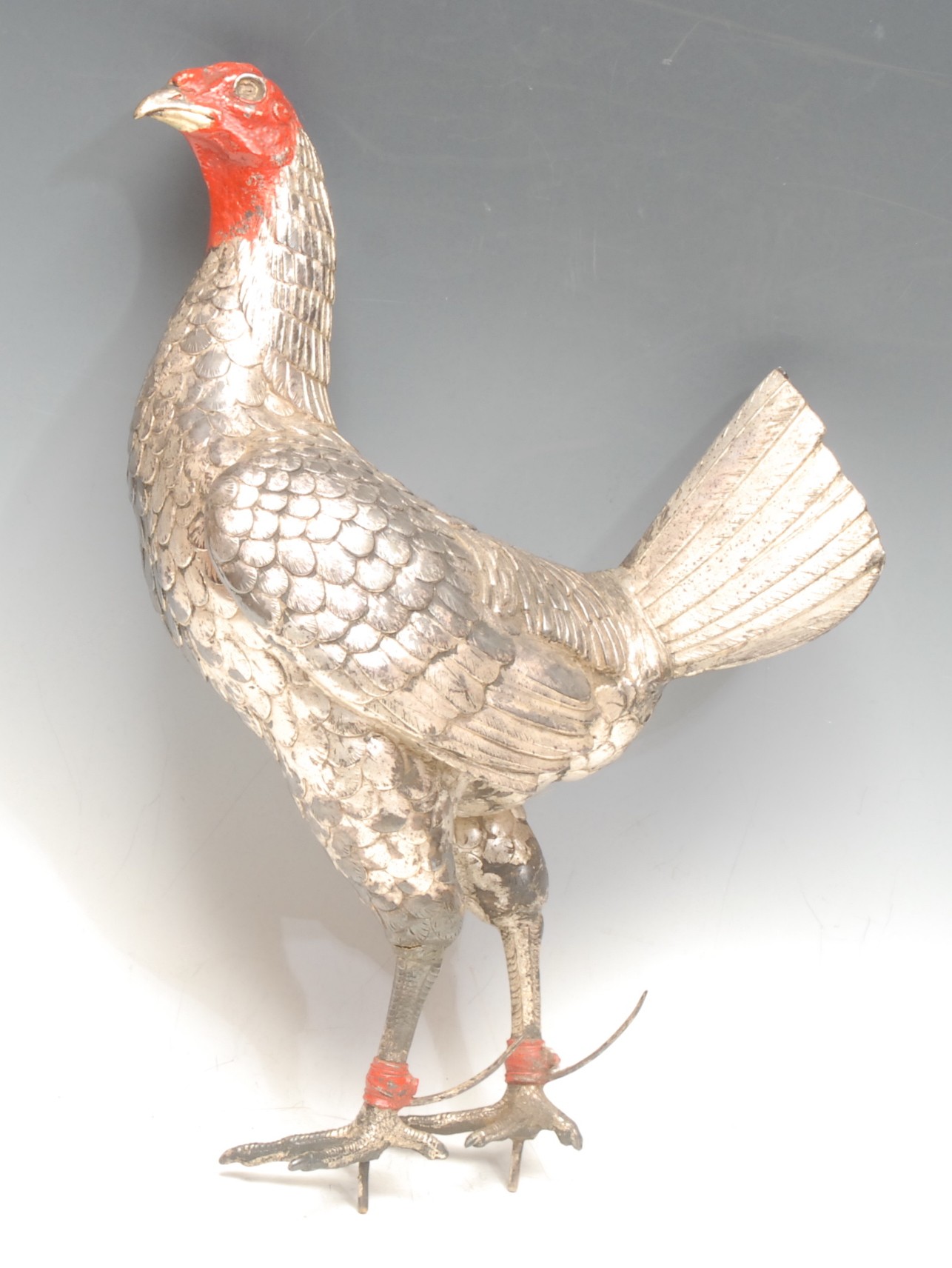 A spelter model of a cockerel, painted in silver and red detailing, 33cm