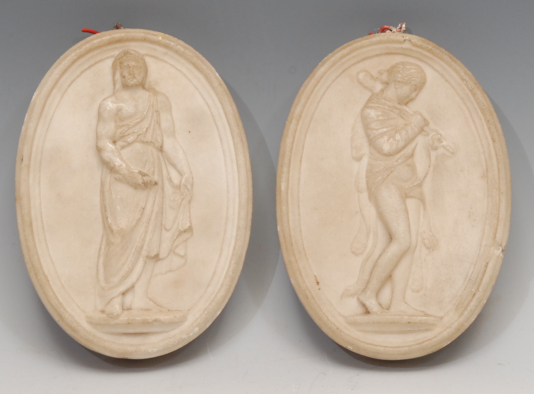 A pair of 19th century Italian Grand Tour Carrara marble oval bas relief tablets, carved after the antique with Classical subjects, 14.5cm x 10.5cm