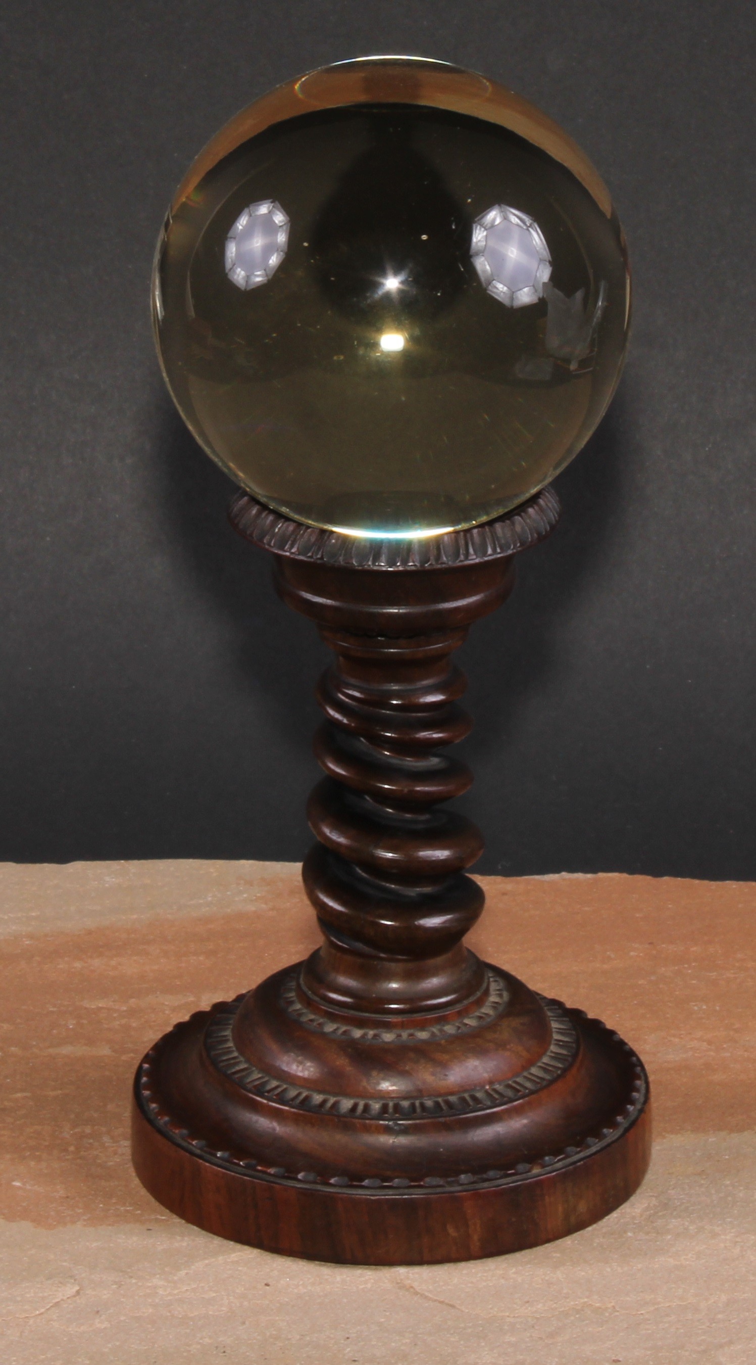 Mysticism and the Occult - a crystal ball, the 19th century stand with spirally turned pillar and circular base carved with a border of stylised lotus, c.1835, 20.5cm high overall