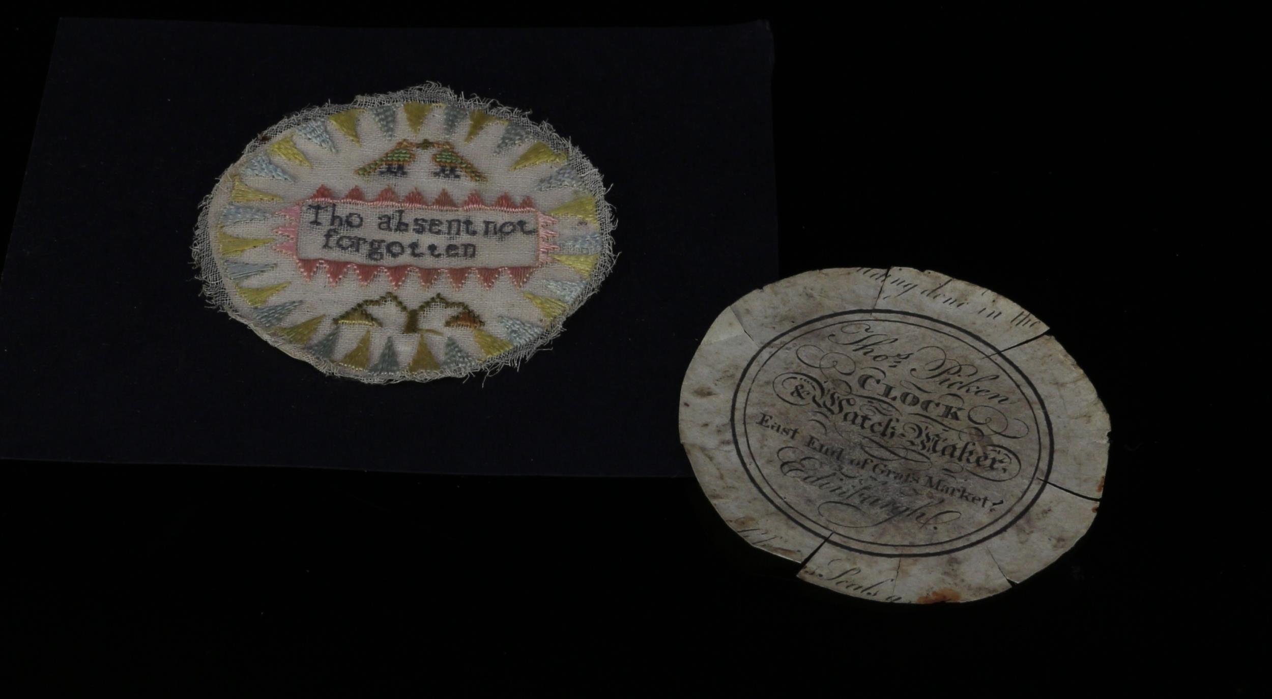 A George III needlework valentine pocket watch sampler, worked in coloured threads with love birds and a flower and inscribed Tho (sic) absent not forgotten, within a dogtooth border, 5.5cm diam, c.1810