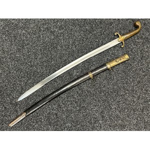 Ottoman Turkish Officers Kilij style Sword with curved double fullered blade 710mm in length. Brass crossguard. Wooden grips. Overall length 860mm. Leather scabbard with brass fittings, twin suspension rings, Star and Crecent to scabbard throat. Additional hanging ring to reverse of scabbard.