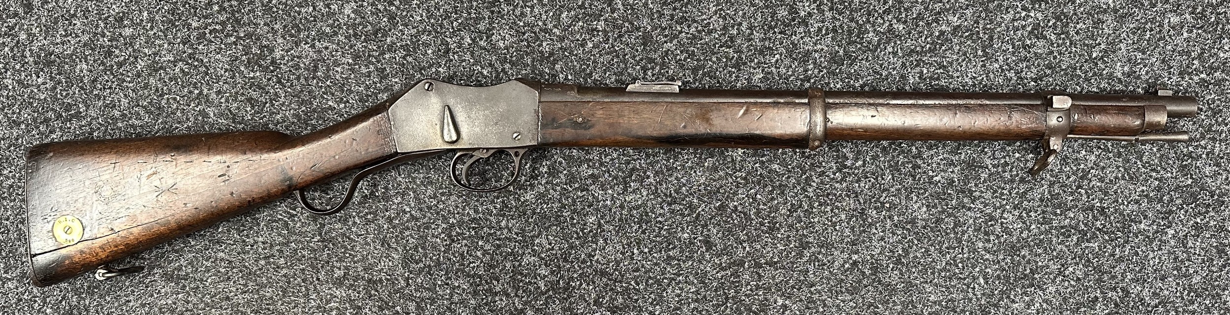 Martini Henry Carbine MKII .450/557 cal. with 525mm long barrel. No visible serial number. Maker marked and dated "Enfield 1885". Working action.  Brass butt identification disc marked "R.I.C 390". (RIC = Royal Irish Constabulary). Stock marked with double Broad Arrow sold out of service marks along with receiver and barrel. Complete with cleaning rod. Overall length 955mm. NOTE: Section 58 (2) Obsolete Calibre, no licence rquired in the UK.