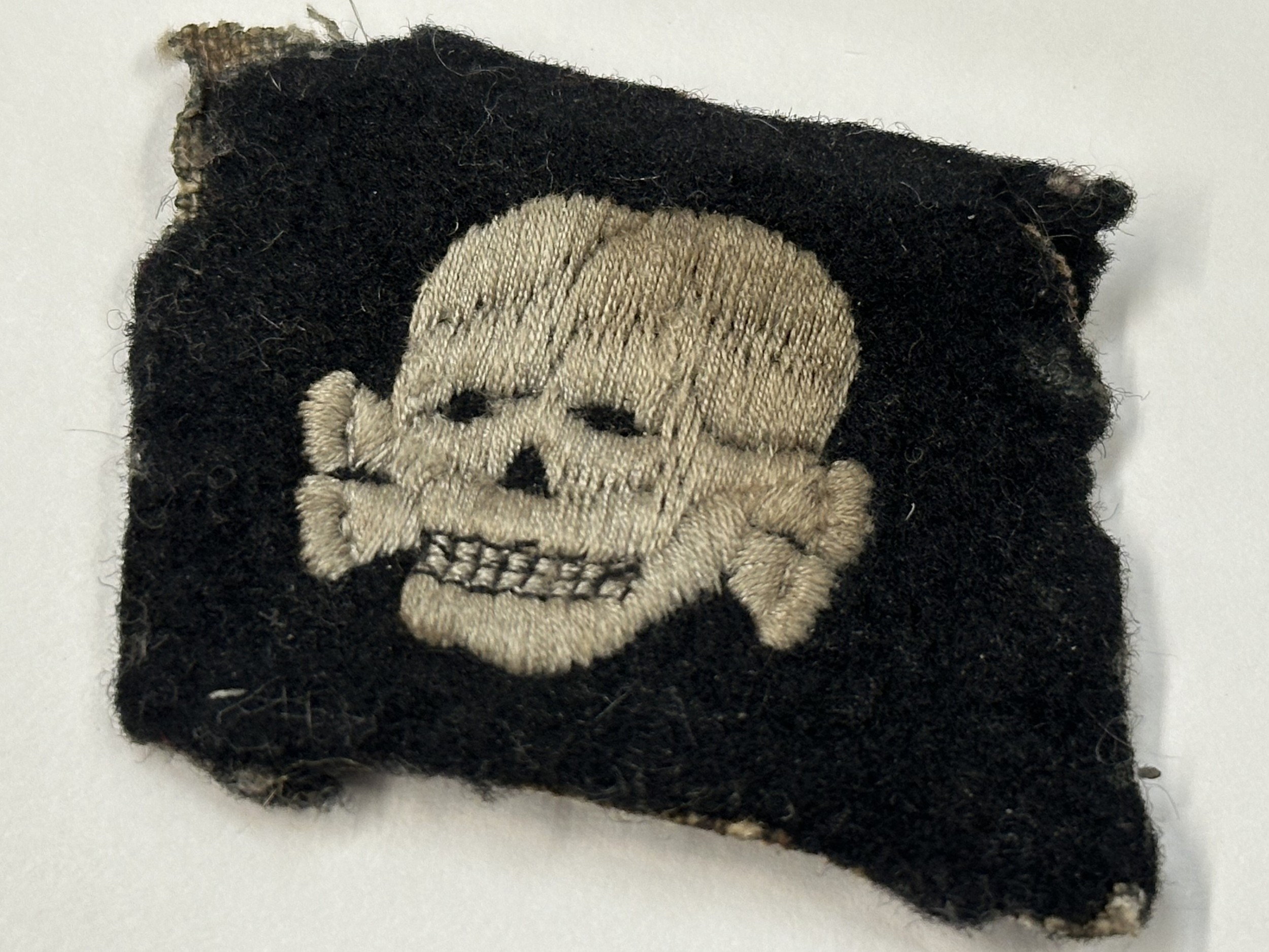 WW2 Third Reich SS Totenkopfverbande rare early pattern collar tab with left facing skull. This item was obtain by a British Veteran of the 63rd Anti Tank Regiment Royal Artillery when his unit entered Bergen-Belsen Concentration Camp in April 1945. New to the market.
