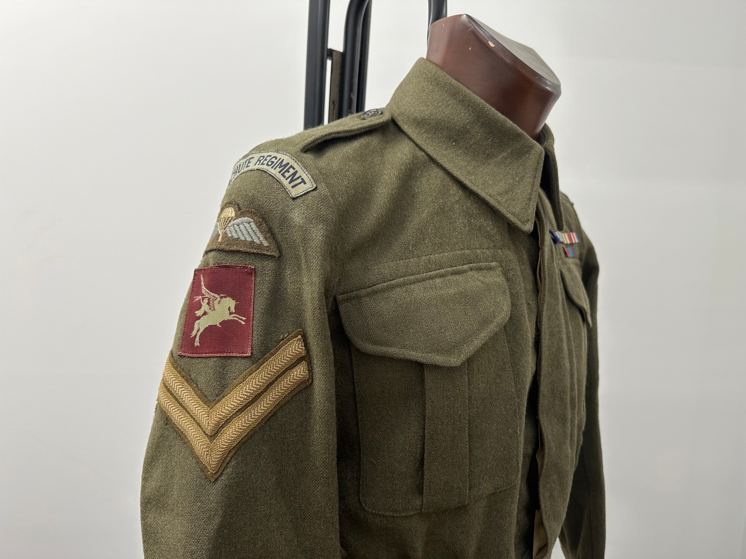 WW2 British Parachute Regiment Australian made Battledress Blouse named to  "Dix, S Coy, 6th" and is additionally named under the breast pocket flap in ink. The Blouse is a Size 4 and is maker marked "HR Hayman Pty Ltd" along with "Blouses, Khaki Cloth, Battle Dress British Pattern, Year 1946". All insignia is originally sewn with printed Parachute Regt shoulder titles and Pegasus formation signs. Corporals stripes are hand sewn in place. Medal ribbon bar is hand sewn. Included is a colour photo of Mr Dix wearing his BD in 1995 for the VE Day celebrations and a re-print photo of him with a PIAT in Italy in 1943. Also included is his Maroon waistcoat often wore at reunions etc. New to the market. (Background info: 1103198 Cpl Fred Dix served originally in the RA from 1940 and later volunteered for the Airborne Forces. Saw active service in Africa, Italy, Greece and Palestine. PIAT gunner in S Coy, 6th Battalion Parachute Regt, 2nd Independent Parachute Brigade.)