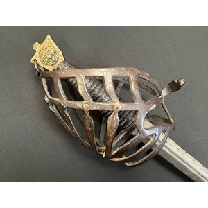 18th Century Italian Schiavona Half Basket-Hilt Sword with double edged blade with short fuller 900mm in length. No makers markings. Iron half basket with wooden grip with leather covering. Brass pommel with grotesque mask to both sides. Overall length 1057mm. No scabbard.
