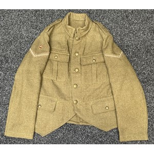 WW1 British 4th Tyneside Scottish Other Ranks Doublet Jacket with Lance Corporals Rank insignia with Brass Flaming Grenade above, war economy 4th Tyneside Scottish Brass & Nickle Shoulder titles, General Service buttons. Jacket is marked with WD Broad Arrow along with inspection codes M and 139. Has brooch pinned cap badge in the pocket along with a small peice of shell driving band shrapnel plus three NF brass shoulder titles and a flaming grenade collar dog. Has two tailor made internal breast pockets added to the inside of the jacket. Tartan flash and Victory medal ribbon iside one of the pockets.