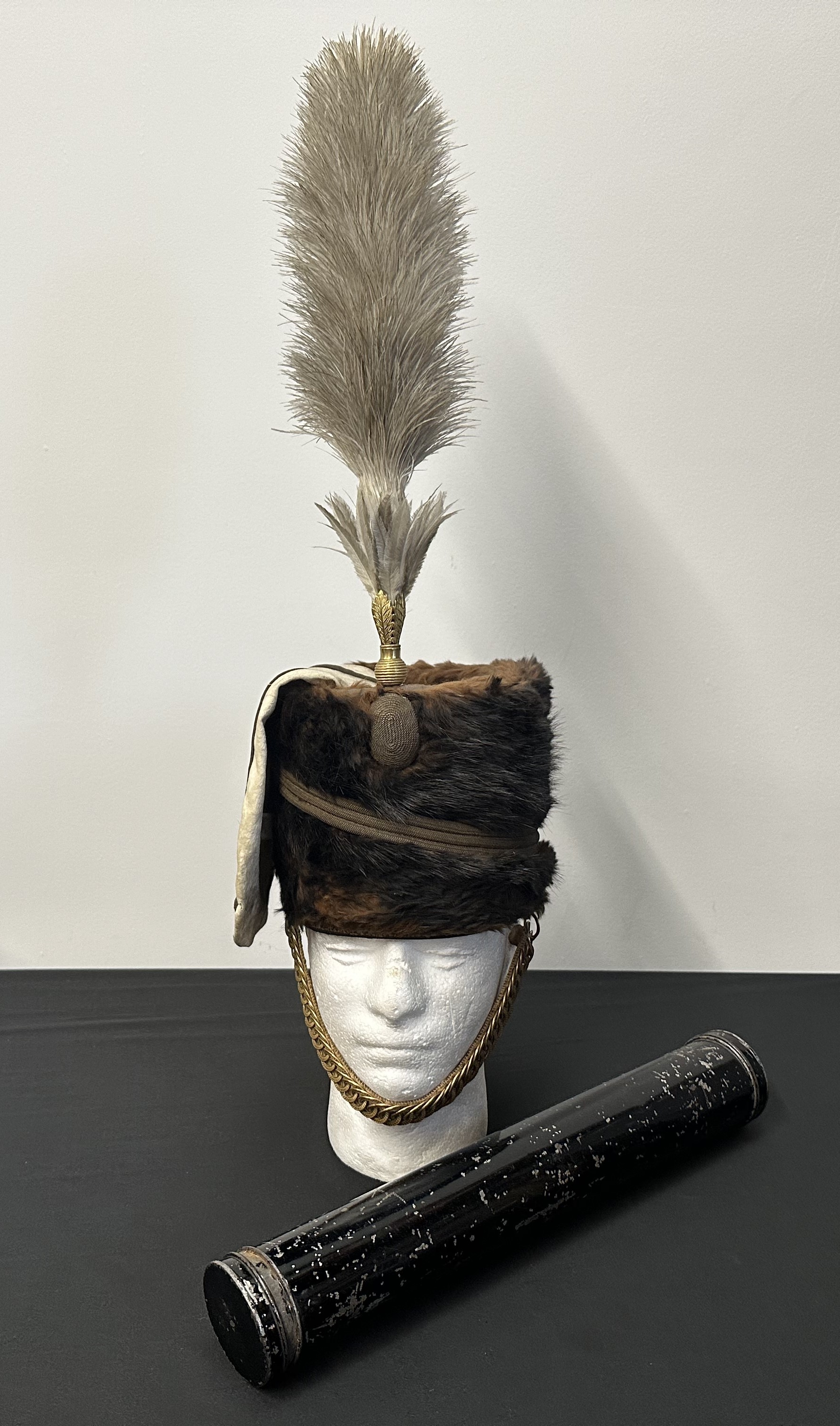13th Hussars Officers Busby with White Bag and Feather Plume. Hussars pattern gilt chinstrap backed with tan leather. Complete with tin for the plume.