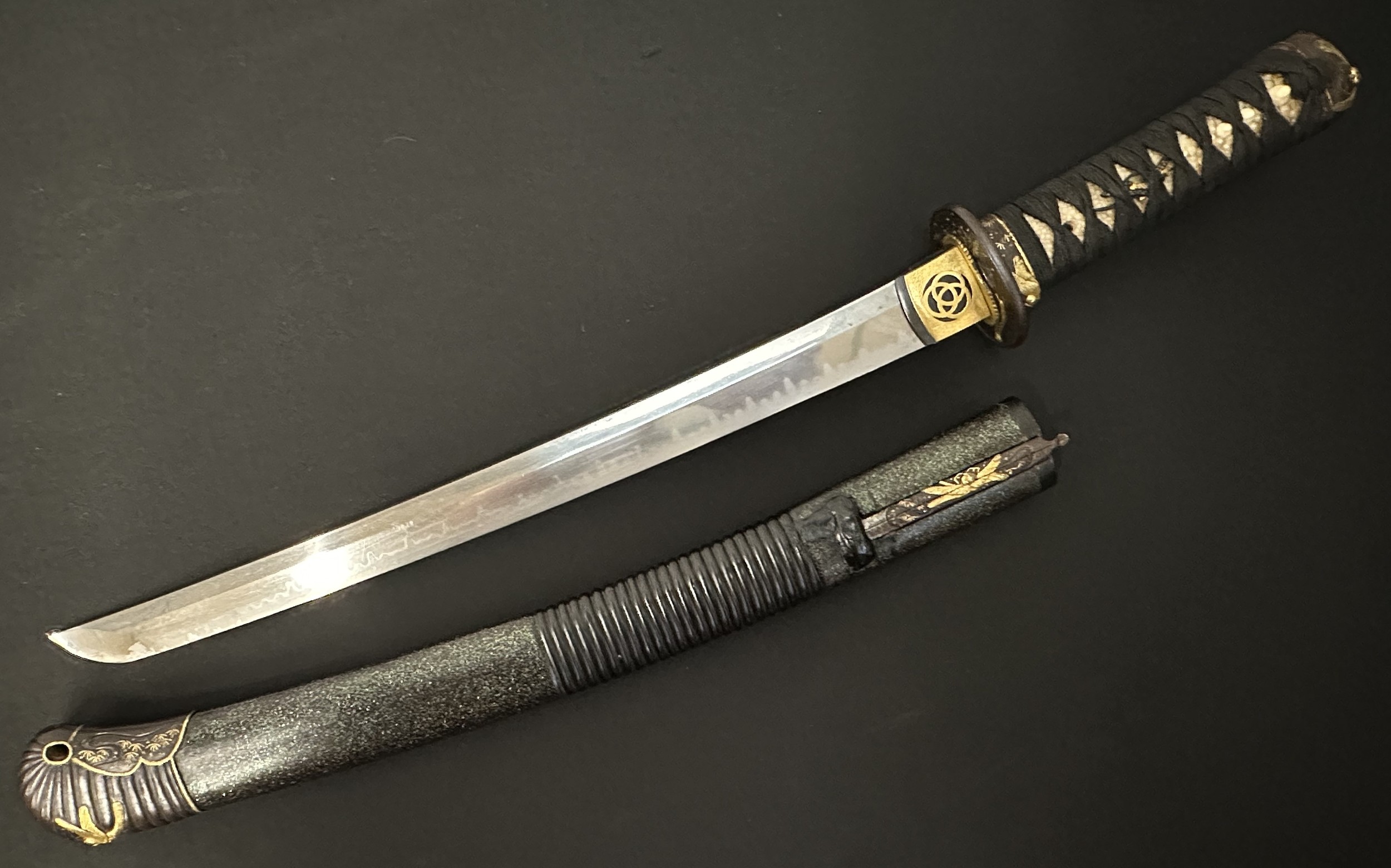 Japanese Wakizashi Sword with single edge blade with good Hamon line 400mm in length. Mon to the Habaki. Tsuba is decorated with Dragonflies. Dragonfly decoration is continued on the Fuchi and the Kashira. Good quality Ray skin covered grip. Overall length 565mm. Complete with ornate laquered Saya with Dragonfly to the tip. Complete with Zozuka knife with signed single edged blade 117mm in length, handle is again decorated with dragonfly design, together with Wari-kogai again with Dragonfly decoration.