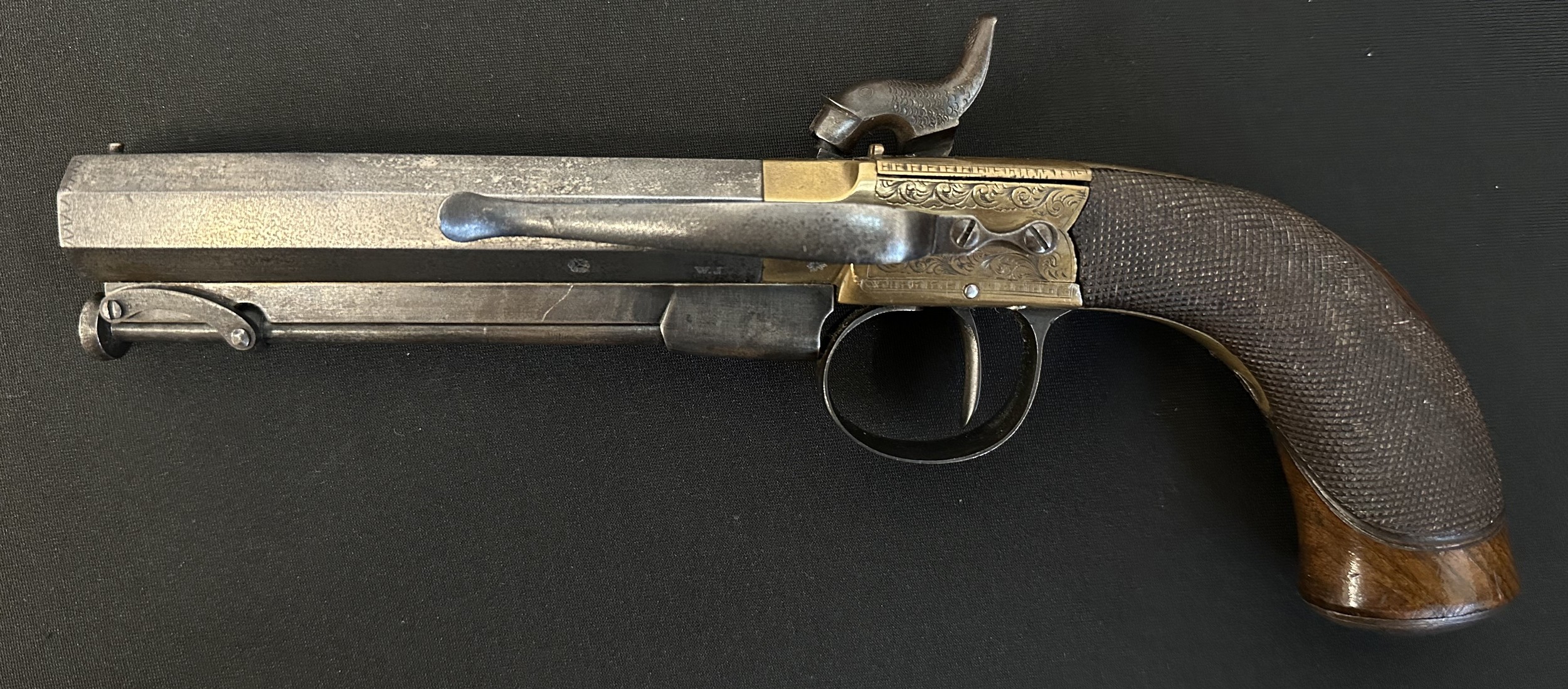 English Percussion Cap Belt Pistol with octagonal barrel 115mm in length. Bore approx. 13mm. Barrel is maker marked "WJ". English Proof marked. Working action which holds at full cocked position. Engraved brass lock. Butt has trap for spare percussion caps. Blank escutcheon plate. Folding ramrod. Overall length 235mm. NOTE: Section 58 (2) No licence required in the UK.