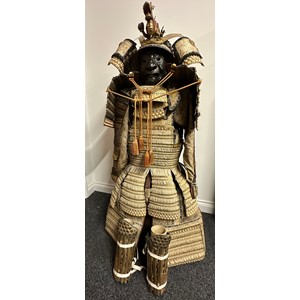 Japanese Samurai Warriors Set of Dō-maru style Armour to include Dō-maru style kabuto helmet with a medieval revival style with Fukigaeshi, wing-like or ear-like projections. Fitted with Wakidate horns and a Golden Dragon. Menpo facial armour or Me no shita ho with brown lacquer finish with teeth picked out in gold and with shikoro leather neck guards. Comes together with a bamboo display stand and with a black storage box, but missing the original lid. The Helmet Dragon also comes with a wooden storage box with 2008 auction label inside. Armour has a Bonhams auction label not dated. Together with some original clothing.