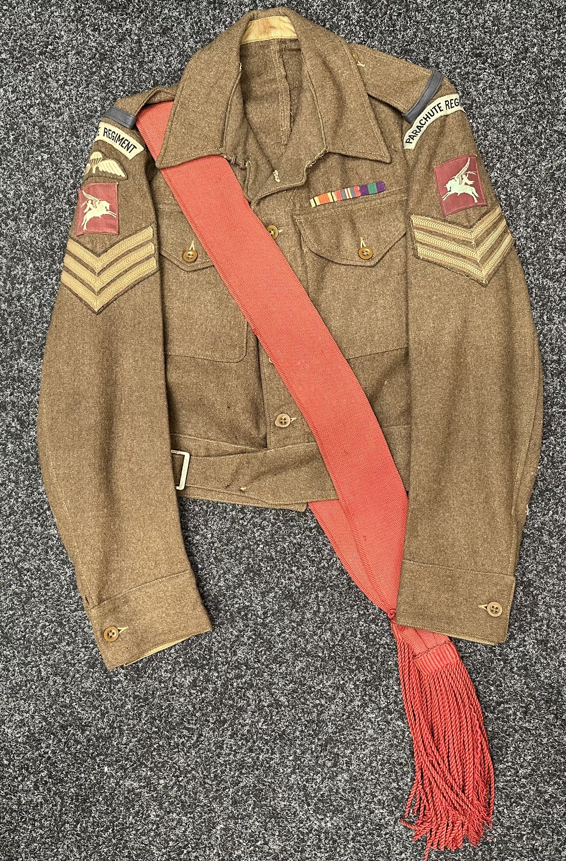 WW2 British Parachute Regiment Midlands Battalion 1940 pattern Battledress Blouse complete with all originally sewn insignia. Printed Pegasus formation signs. Parachute wings. Colour Sgt's rank insignia. Named to "Kirkland WR 14941343". Size 10. Maker marked and dated "JD Feldman & Co, Belfast 1945". WD inspection code marked Z for 1945.