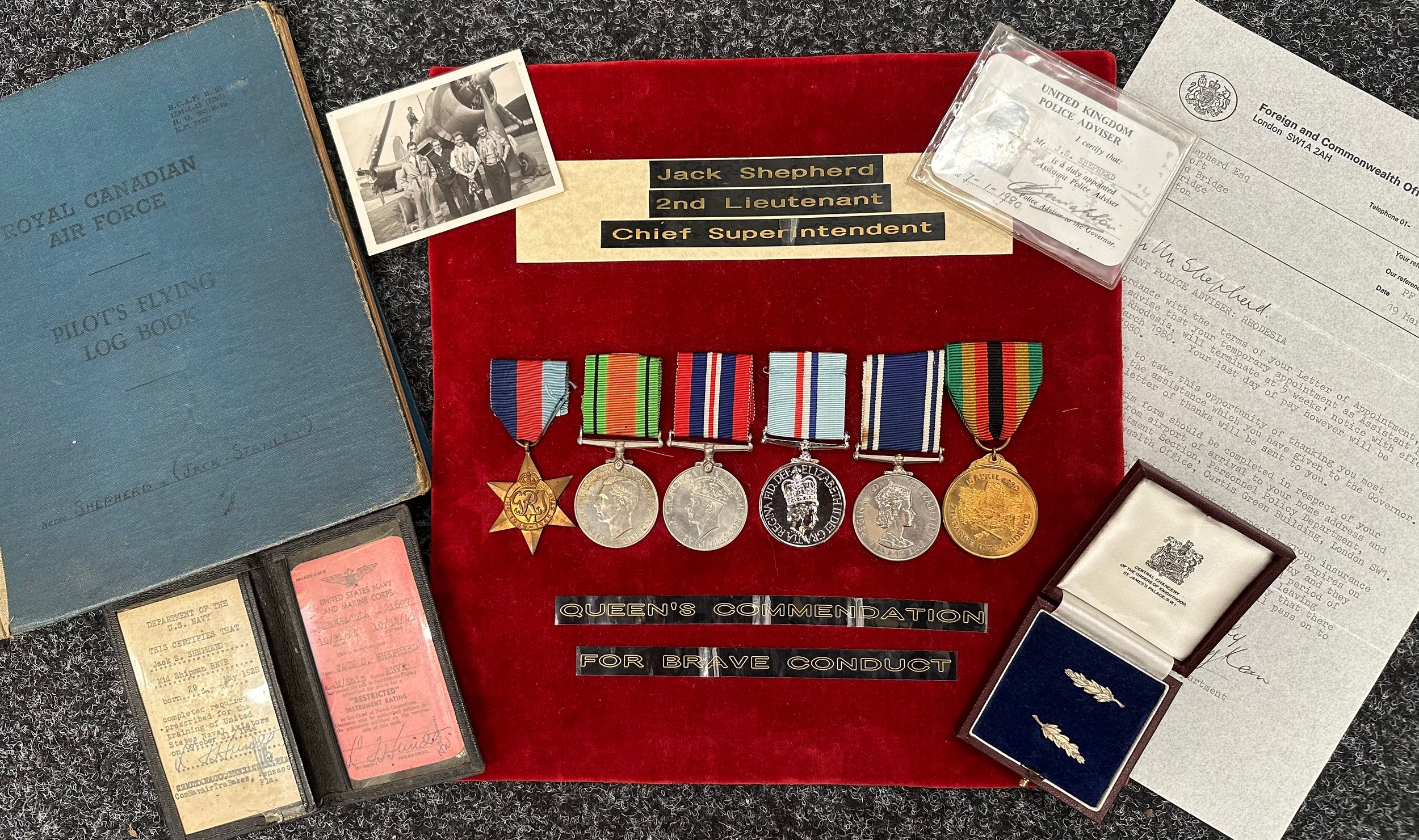 Police Operation Agila Rhodesia and WW2 RNVR Fleet Air Arm Medal group with Flying Log Book to 2nd Lieutenant / Chief Superindendant Jack Shephard. This is a very comprehensive group which includes much documentation. The medal group consists of : 1939-45 Star, Defence Medal, War Medal, Rhodesia Medal, Police Long Service and Good Conduct Medal, Zimbabwe Independence Medal all complete with ribbons along with cased Queen's Commendation for Bravery. Jack Shepherd had a very sucessful career in the Police after leaving the Royal Navy where he was a Pilot in the RNVR Fleet Air Arm. Commended for Bravery and later he led the British Police Contingent to Rhodesia in Operation Agila to help supervise a free and fair election to majority rule. Much documentation.