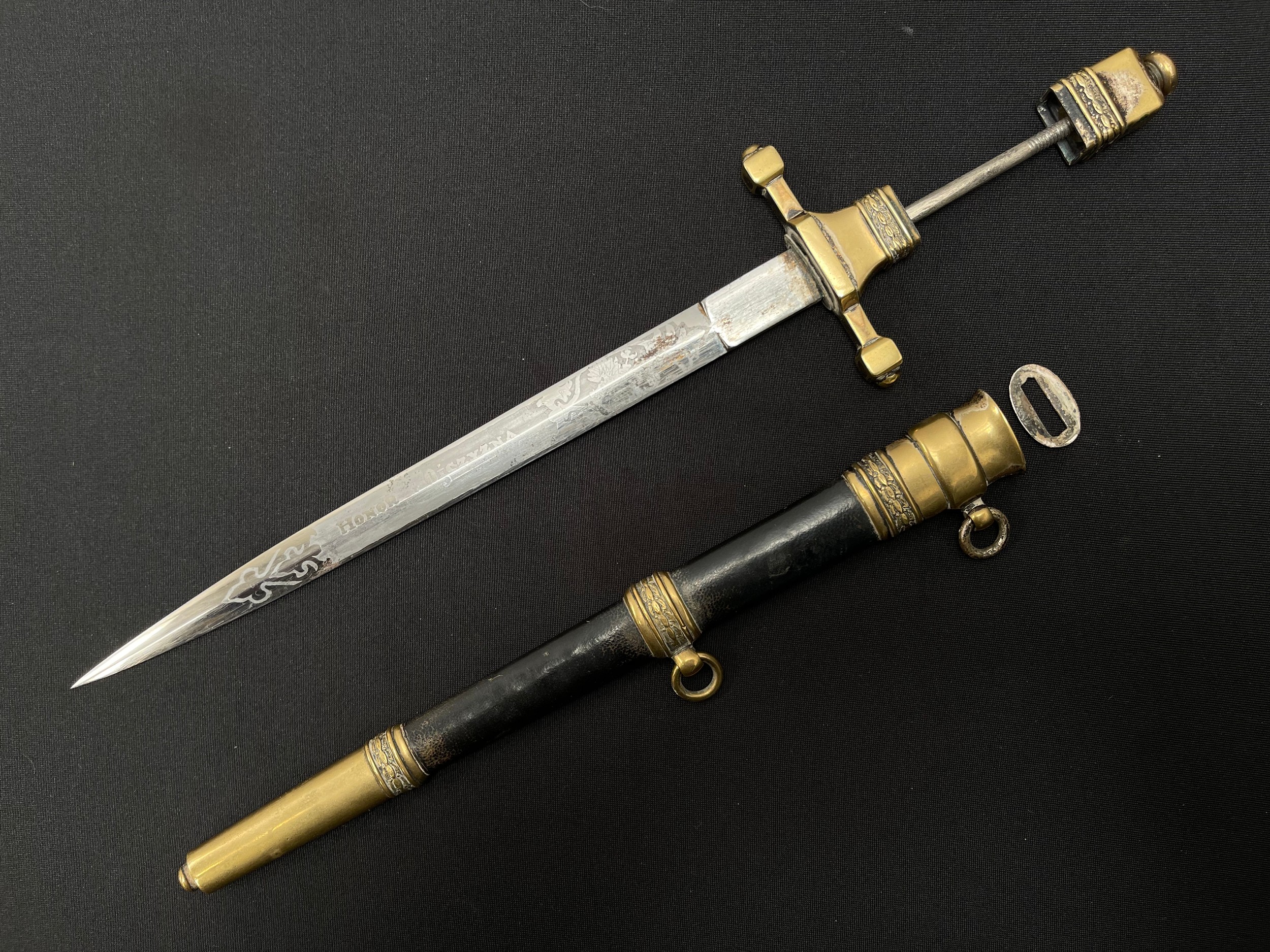 WW2 Polish Naval Officers Dagger with double edged blade 235mm in length with etched panel featuring a Polish Eagle and the motto "Honor  i Ojczyzna" (Honour & Fatherland). Maker marked "G Borowski". Overall length 345mm. Complete with leather bound scabbard. The scabbard throat which holds with blade keepers is loose and required repair.