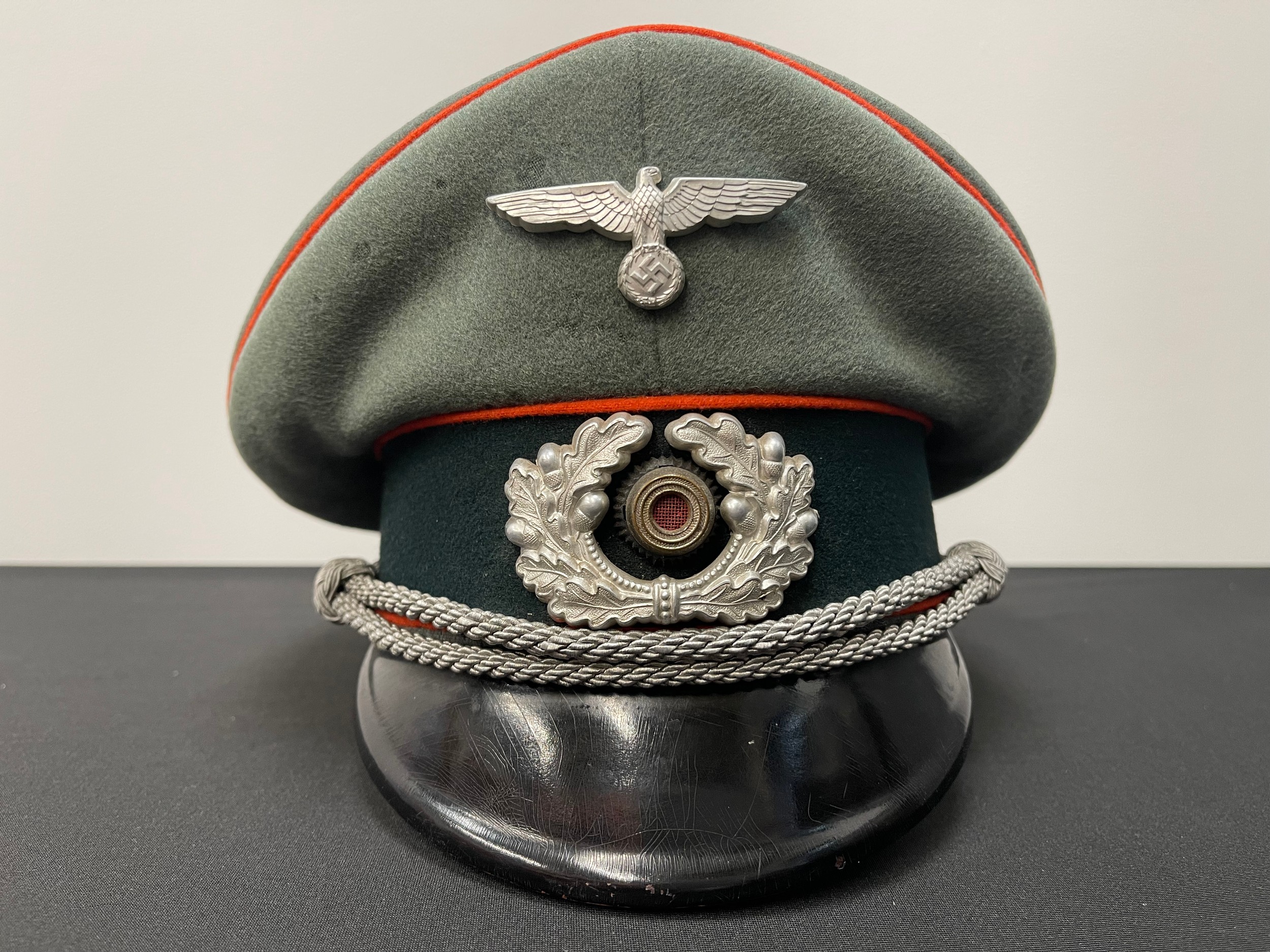 WW2 Third Reich Heer Infanterie Enlisted Mans / NCO's Schirmmutze Cap. Private Purchase Example maker marked to celluloid sweatsheild "F. Eckhard, Hanau" along with "Stirndruckfrei Deutsches Reichpatent". Metal letters pinned to the leather sweatband in the form of the original owners initials "GJ". Size approx. 58.