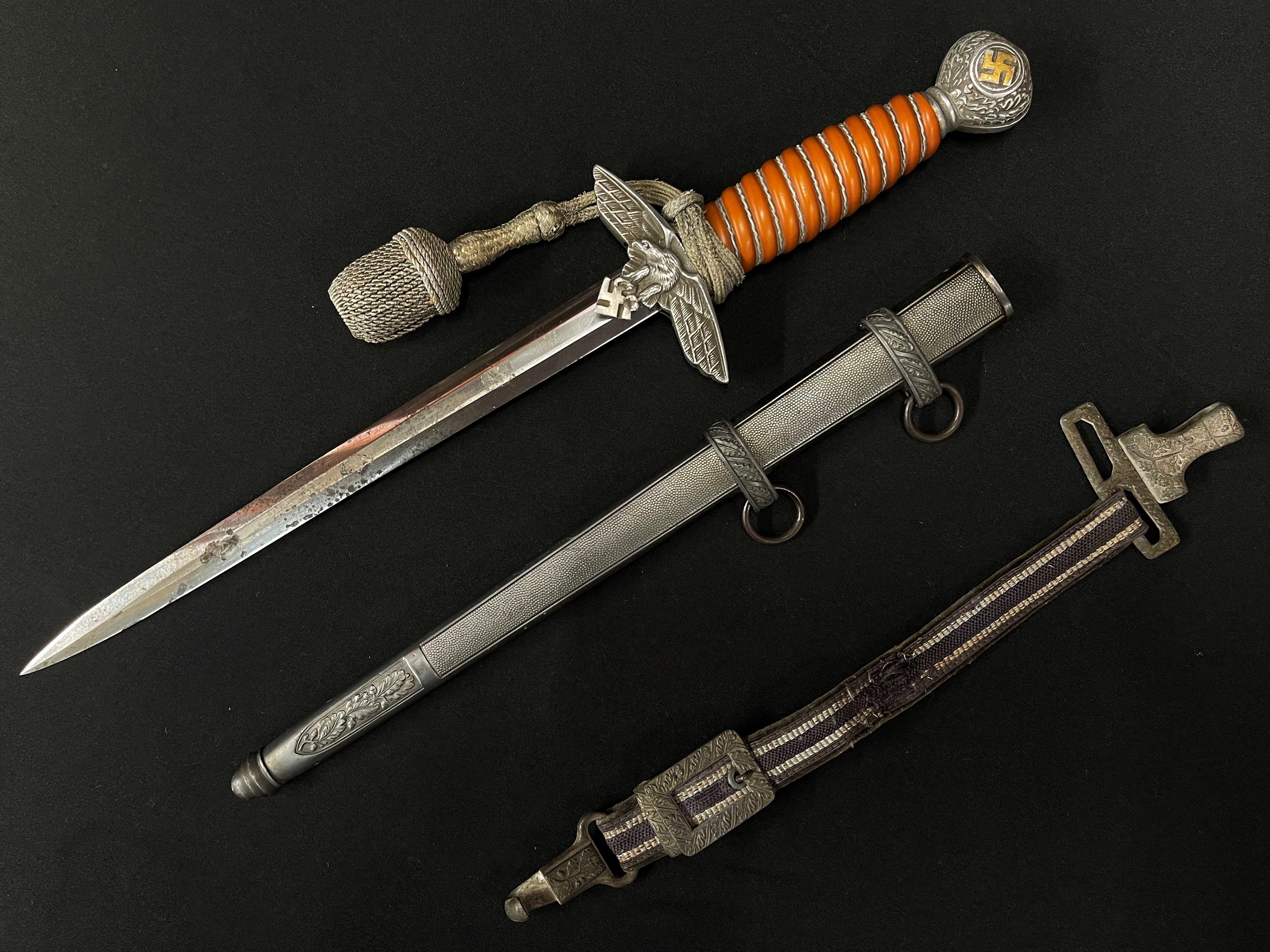 WW2 Third Reich 2nd Pattern Luftwaffe Dienstdolch Officers Dagger with 250mm long double edged blade maker marked "Original Eickhorn, Solingen". Orange Trolon wire bound grip. Pommel retains original gilding to the swastika. Overall length 387mm. Complete with original knot and scabbard. Also has the remains of the hanger. New to the market, war souvenir of a member of the British Army who traded cigarettes for the dagger in Germany in 1945.