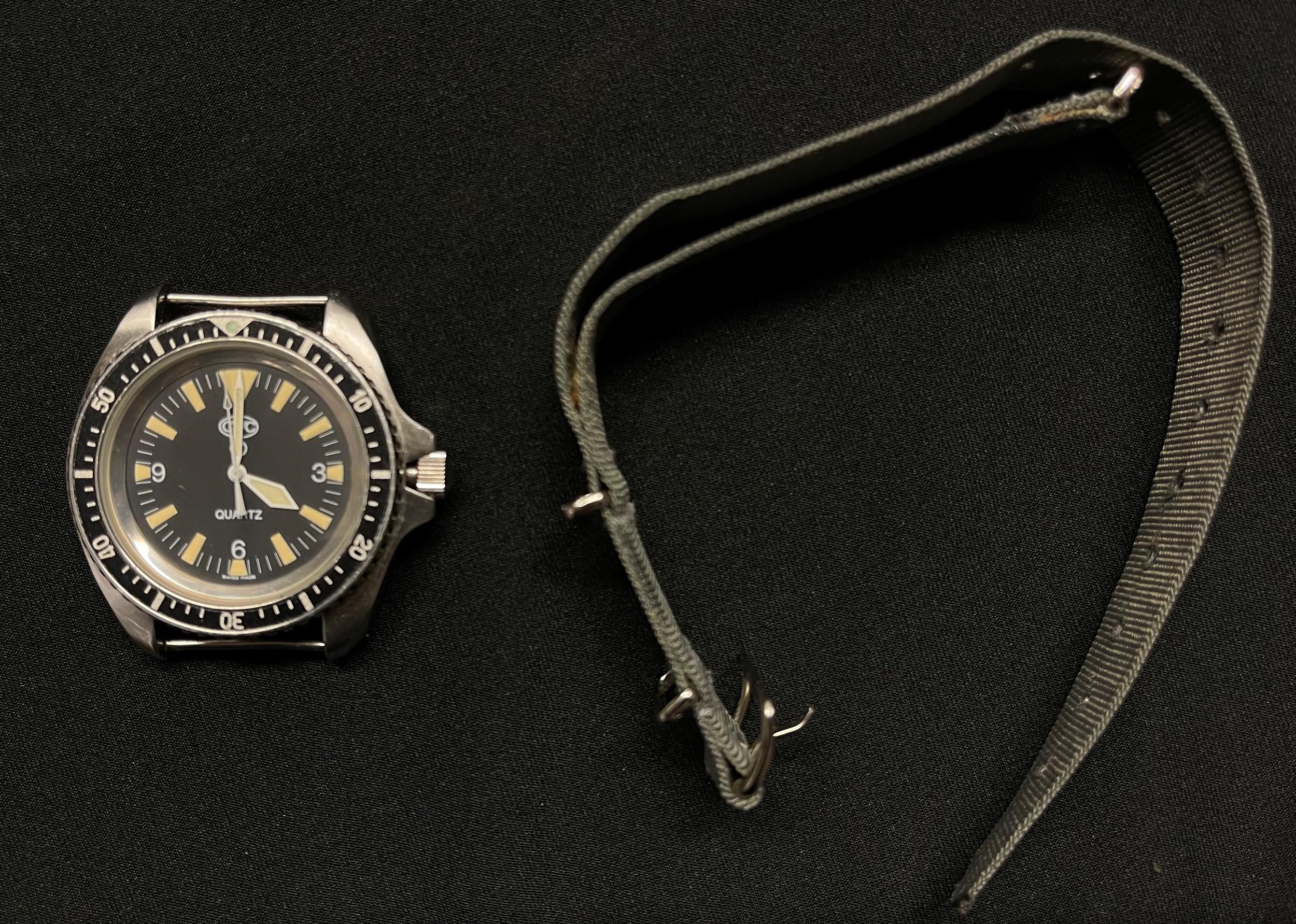 British Royal Navy Divers Quartz Wristwatch by CWC. Black dial with Arabic numerals, marked "Swiss Made". Case marked "0555/6645-99" along with "7573314" plus WD Broad Arrow and "268 94". Complete with original strap.