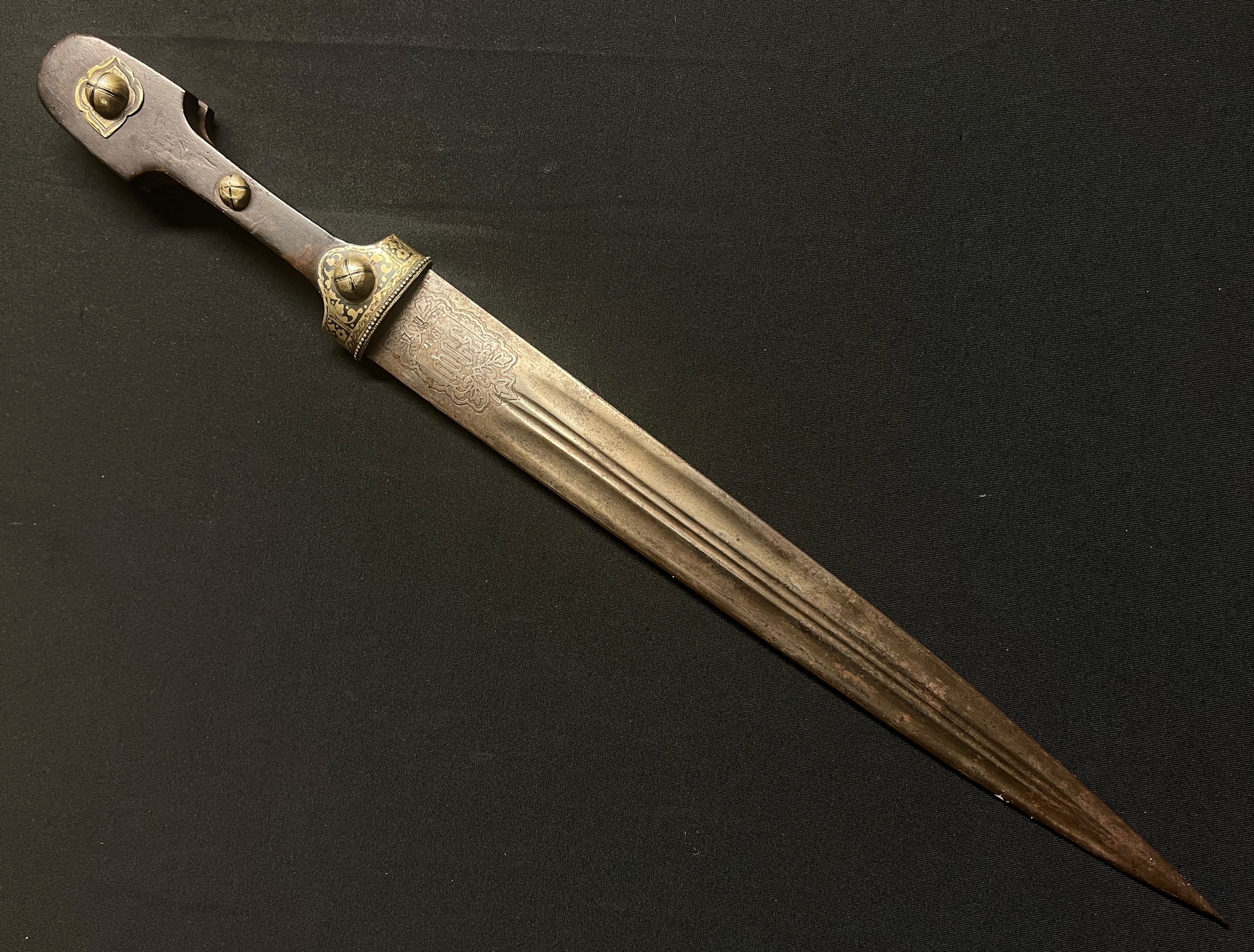 Imperial Russian Kuban Cossacks M1904 Kindjal Dagger with double edged fullered blade 334mm in length. Dated 1911r. Zlatoust Arms Factory. Cyrillic markings to both sides of the blade along with etched decoration. Two die stamped inspection marks. Wooden grip with three studs and Niello decoration. Overall length 479mm. No scabbard.