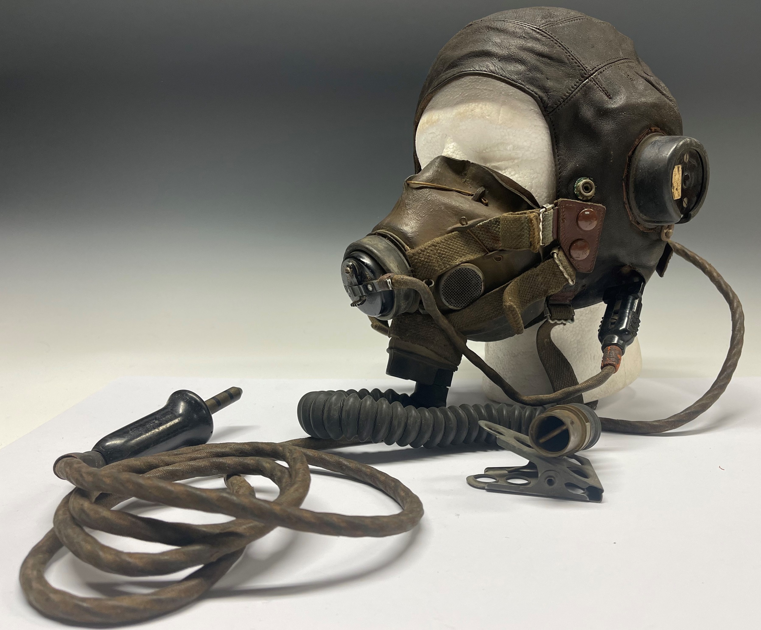 WW2 British RAF C Type Fling Helmet complete with headsets and wiring loom with jack plug together with matching G Type Oxygen Mask. Ex Flying Officer Hands. Together with his RAF cap badge (missing one lug) and various RAF payslips named top him. NOTE: Lot no 5210 in this sale features his log books and photos. New to the market.