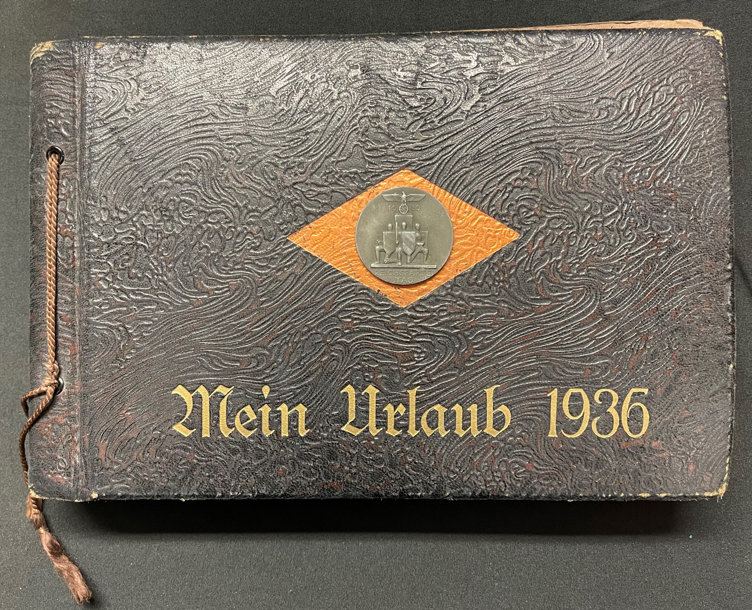 WW2 Third Reich "Mein Urlaub 1936" ("My Holiday 1936") Private unpublished photograph album. Size 29cm x 19cm. Reichspartei Tag 1936 rally badge affixed to the cover. The album is very well presented with captions, photographs, newspaper cuttings, postcards, etc. Unpublished photos of Hitler, Rudolf Hess etc taken outside the Hotel Deutscher Hof. Over 200 photos, all showing very good content, NSDAP, SA, SS inc LSSAH, Blood Flag, Fuhrer Standard, Feldherrnhalle, Ehrentempel. Each location is captioned, Nuremberg, Munich, Party Rally Stadium, Wehrmacht, SS, SA, Zeppelin, Other cities include Erfurt, Wartburg, Frankfurt am Main, Heidlberg. Includes pre printed personal invite from Hitler to the Bulgarian PM (not filled in), Dec 1943 Hitler Xmas and New Year Thank you card, Waffen SS Newspaper and magazine articles, Army enlistment papers, etc, etc.