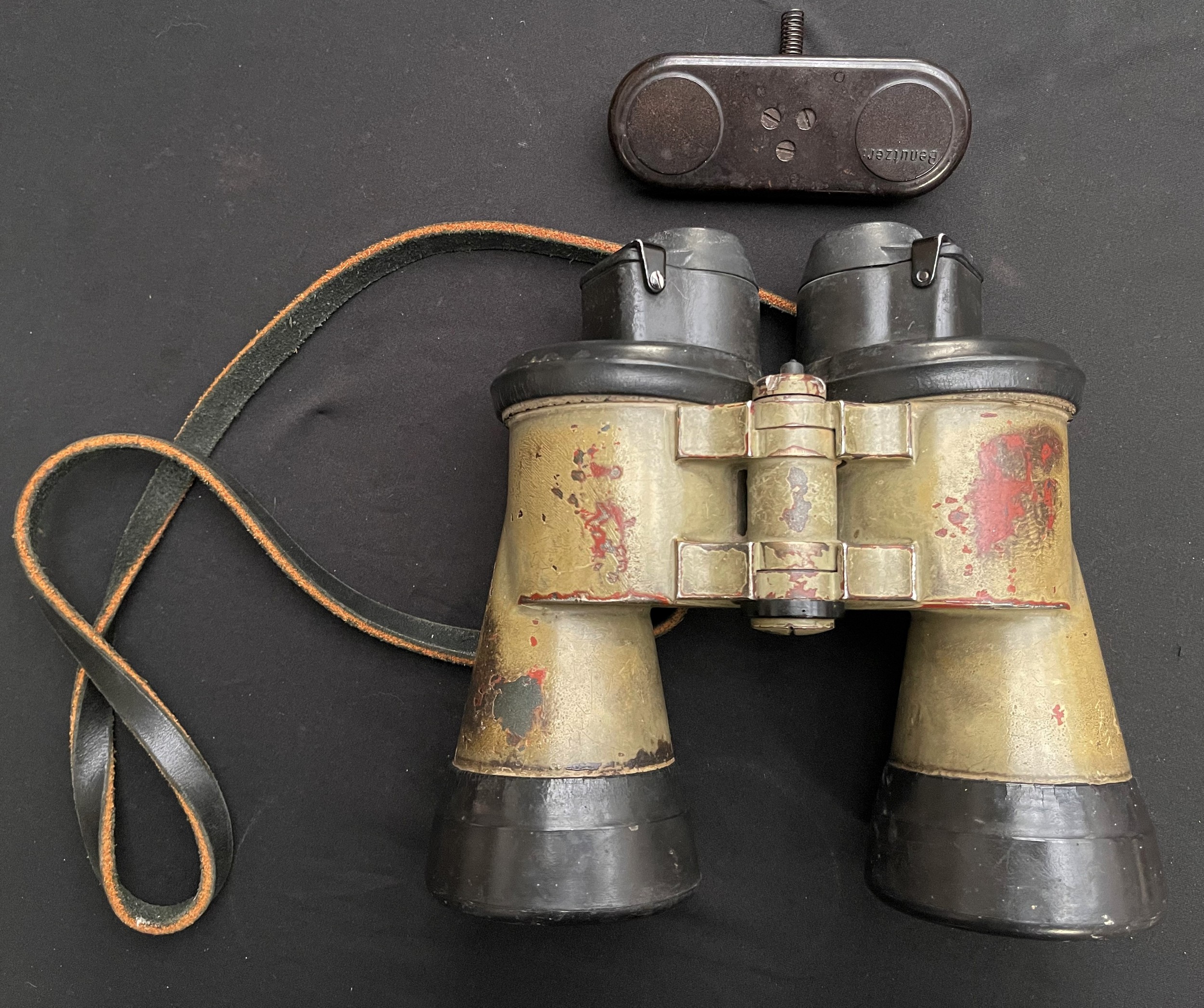 WW2 Third Reich German U-Boat 7x50 binoculars, maker marked "blc" along with serial number 55317. Complete with rubber armoured covers and original black leather neck strap plus bakelite lens cover marked "Benutzer". Original paint finish.
