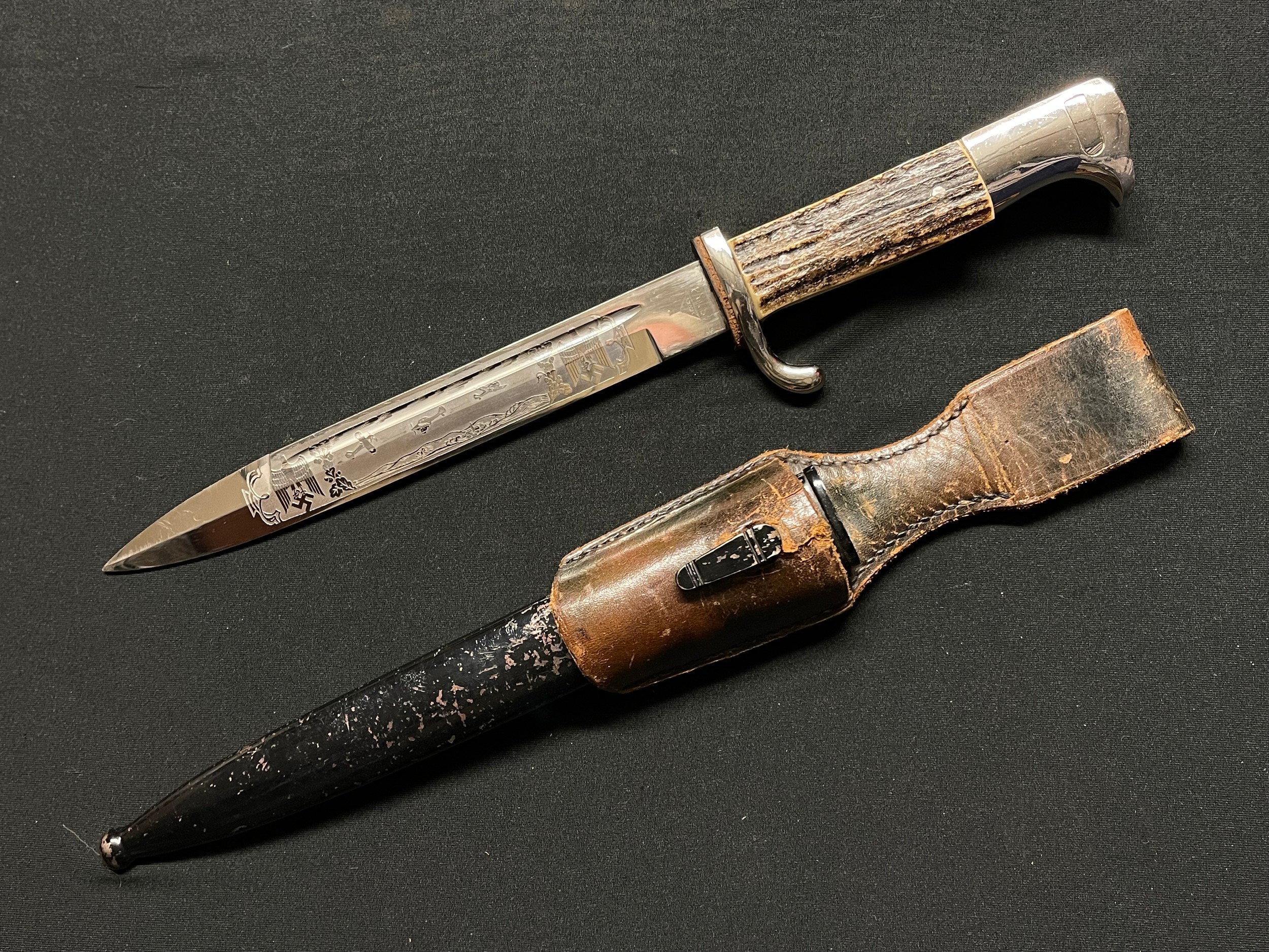 WW2 Third Reich Luftwaffe Short Pattern Dress Bayonet with fullered single edged blade 195mm in length maker marked "Paul Seilheimer, Solingen" and with etched decoration to both sides of the blade comprising of  "Zur Erinnerung an Meine Dienstzeit" and an Airfield Scene with Ju87 Stuka Dive Bomber in flight flanked by Eagle and Swasitkas. Stag Horn Grips. Red Felt insert to slot. Overall length 320mm. Complete with scabbard and correct leather frog.