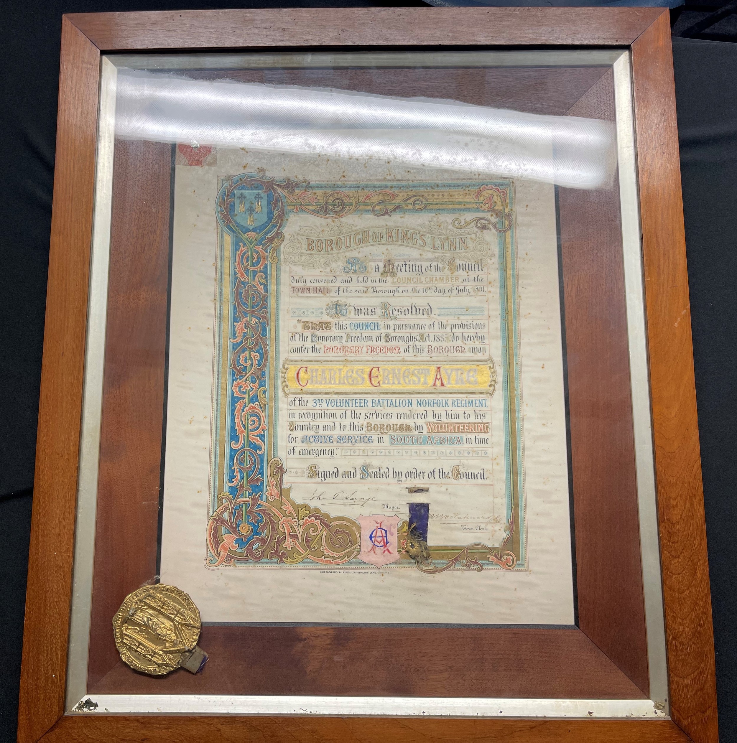 Boer War interest:  Large framed scroll from the Borough of Kings Lyn to Charles Ernest Ayre giving him Honourary Freedom of the Borough after his service in the 3rd Volunteer Battl The Norfolk Regt for service in South Africa. (Note; the scroll is in good condition dirt is on the inside of the glass and not against the paper)